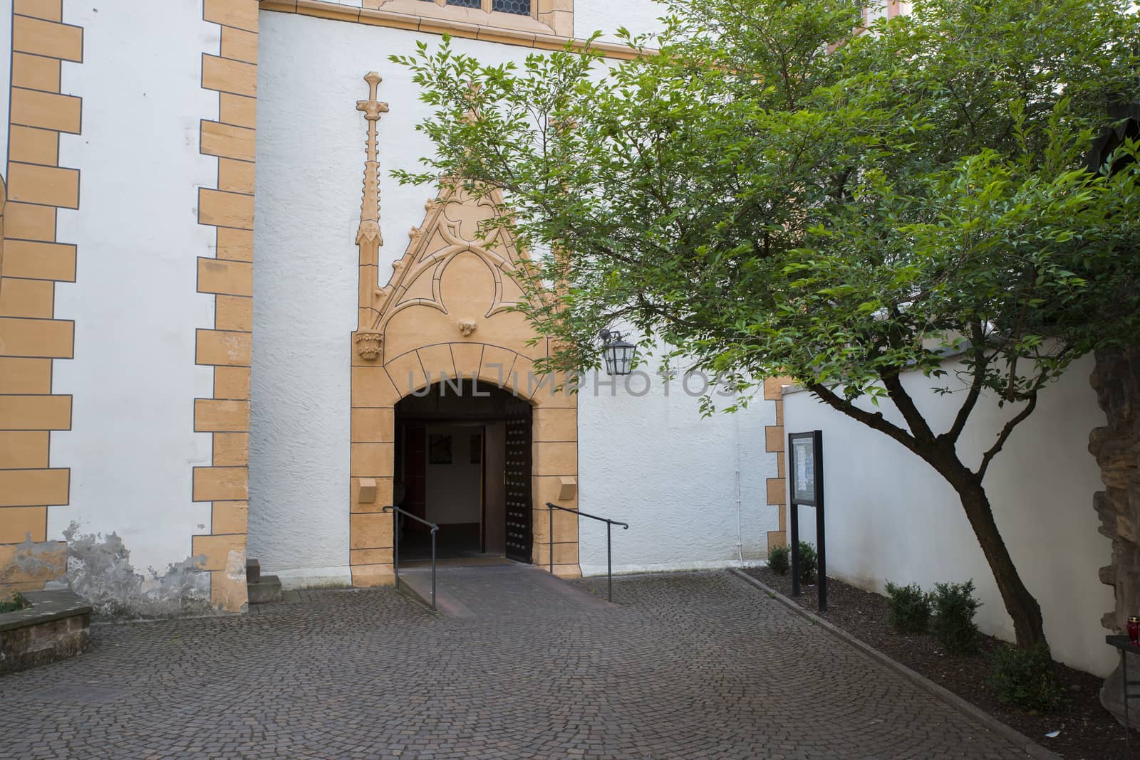 entrance of a church in trier with patio garden with tree and plants