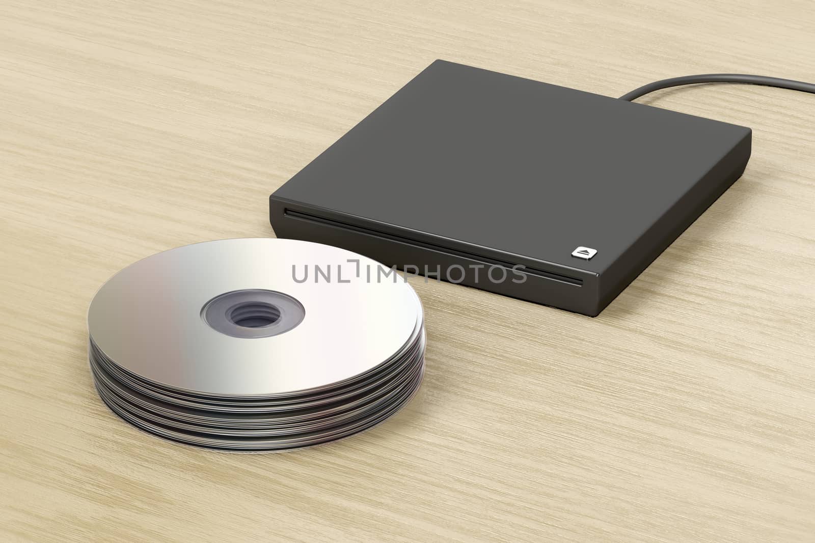 Stack of optical discs and external slot-loading optical drive on wood table