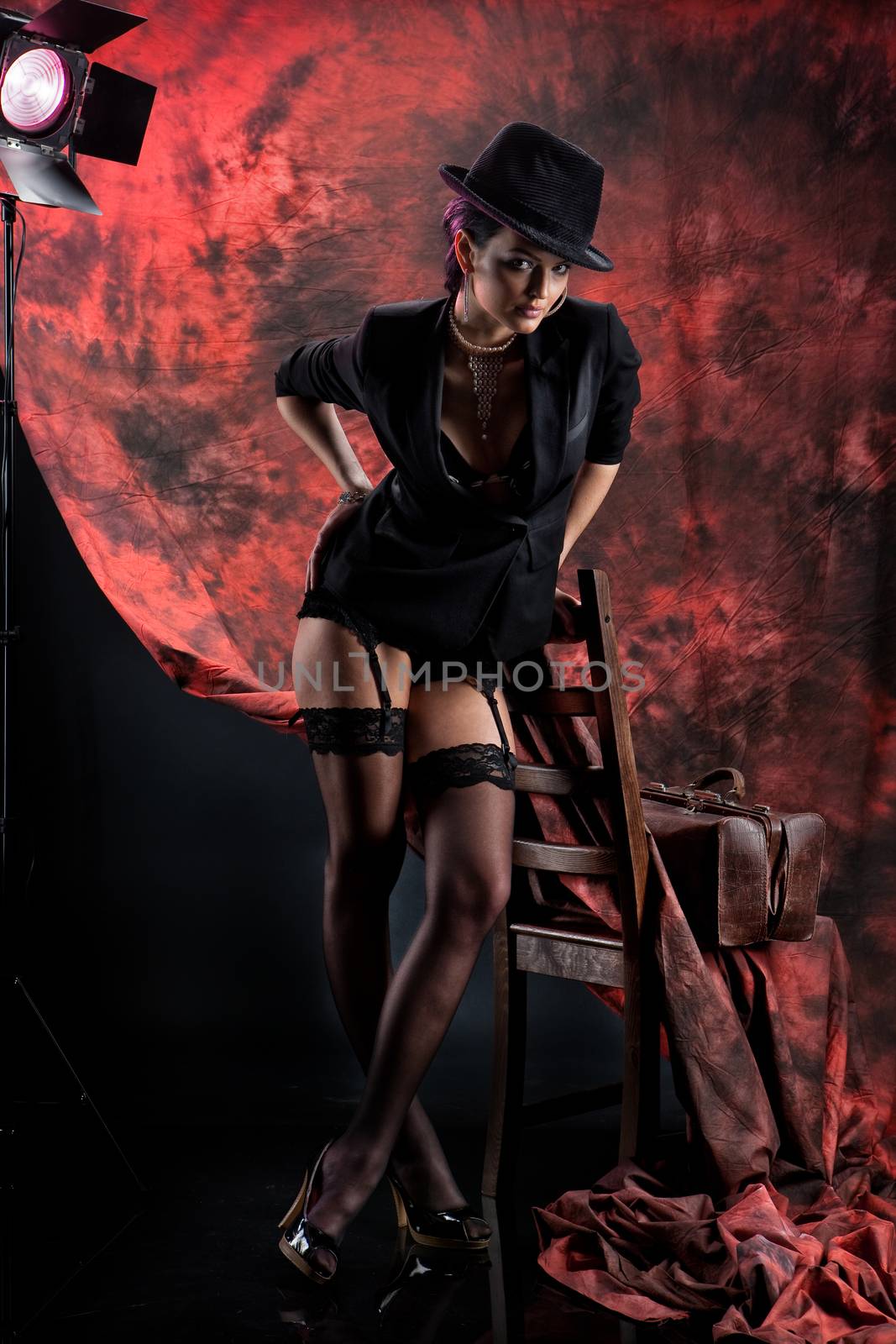 Young beautiful woman in a fashionable clothing on a studio background