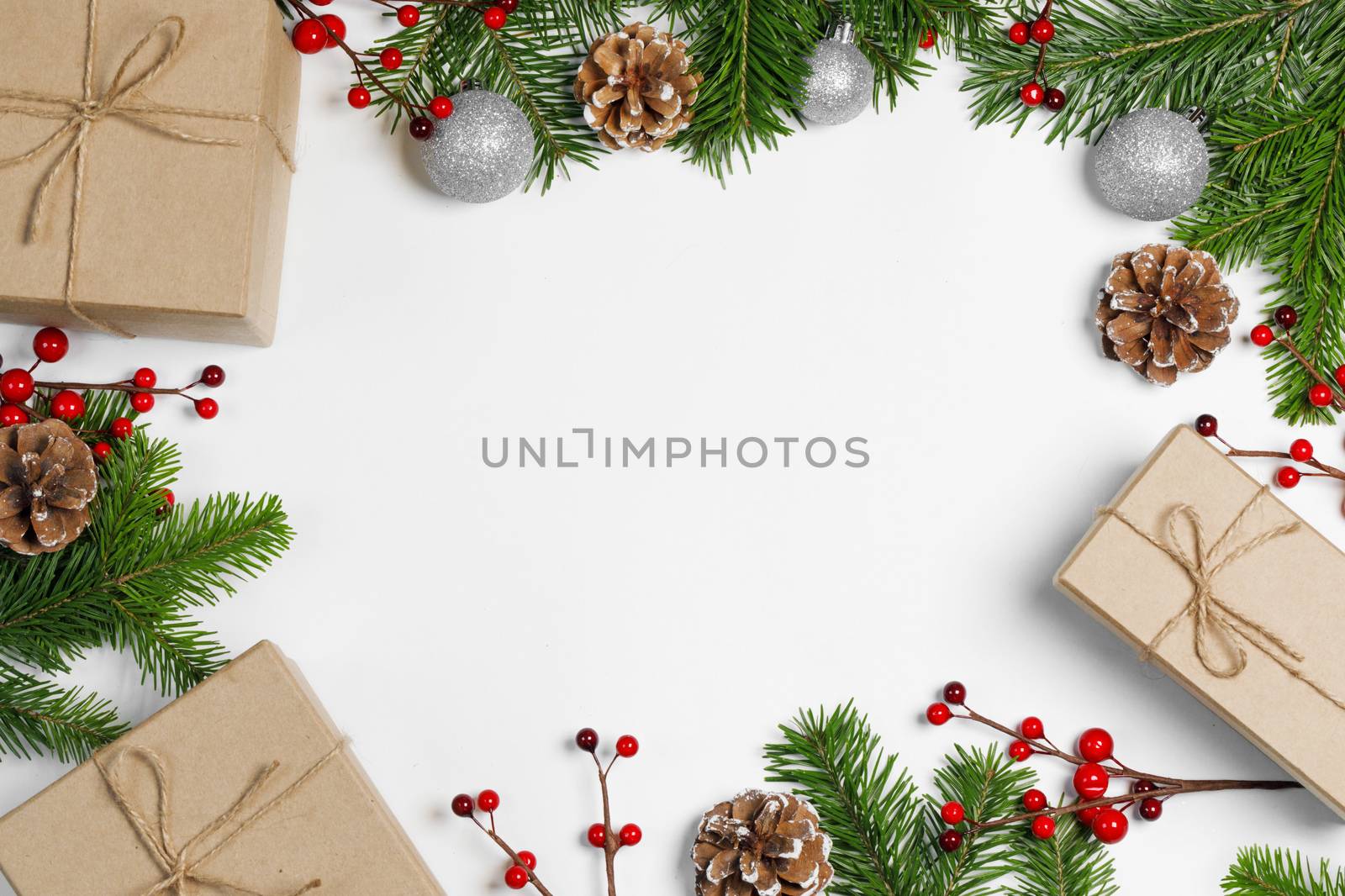 Christmas frame background. Fir tree branch, balls, gifts, silver balls and berries isolated on white. Top view with copy space.