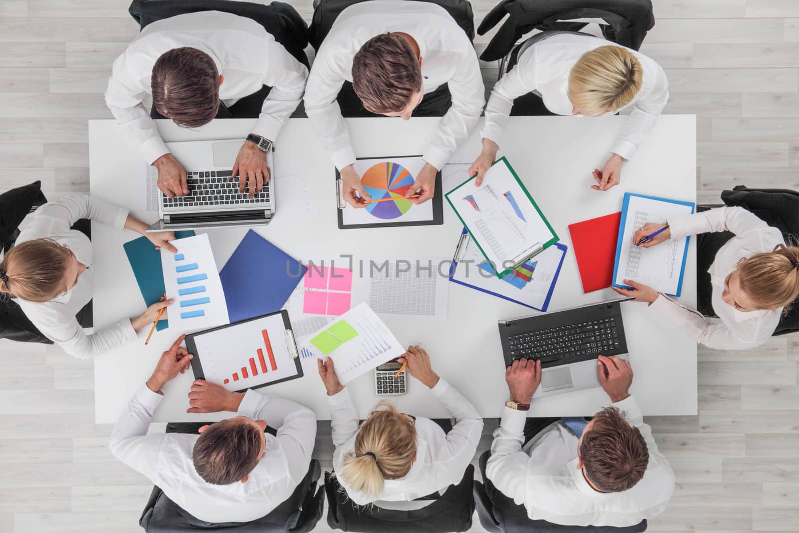 Business people work with statistics documents with tables and diagrams sitting around the table