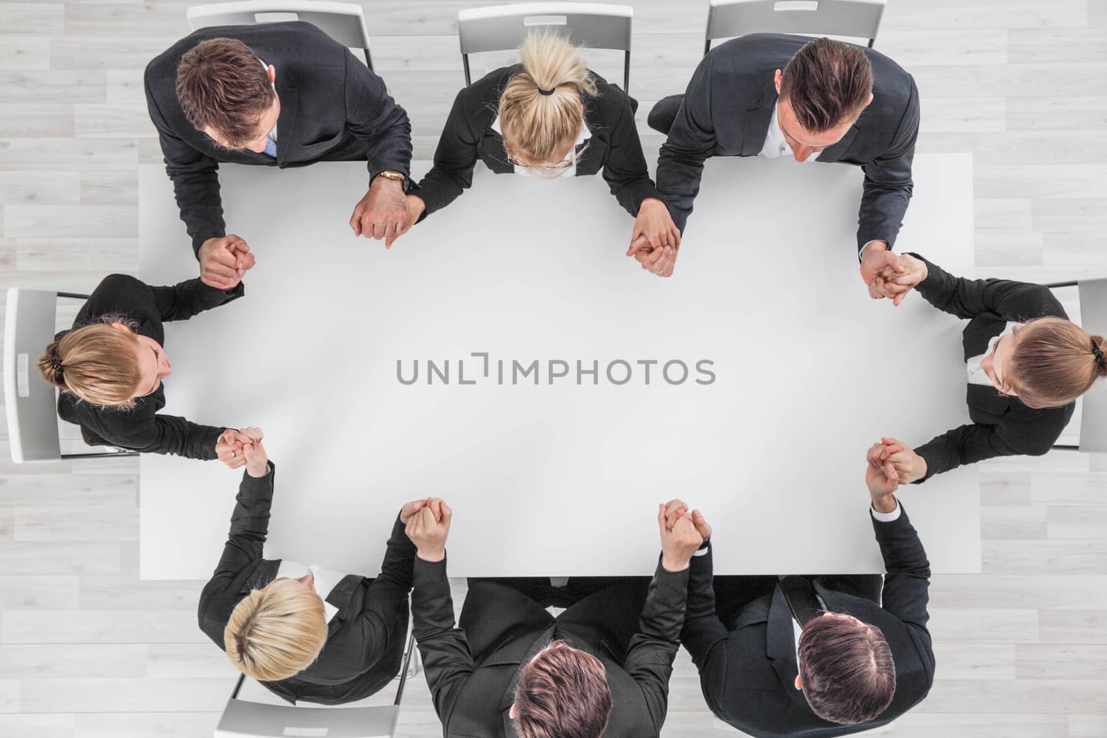 Business team holding hands sitting around the table, top view , copy space for text