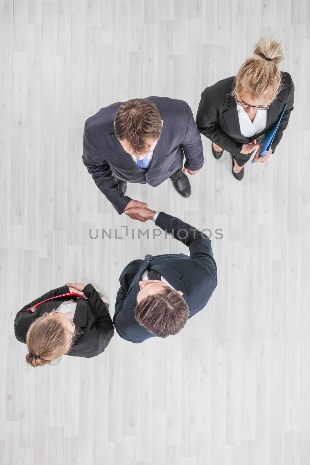 Business people shaking hands, finishing up a meeting, top view