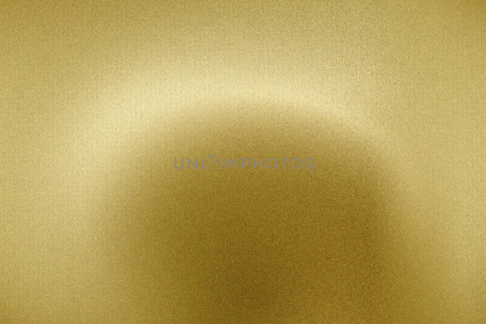 Light shining on brushed gold metal panel, abstract texture background