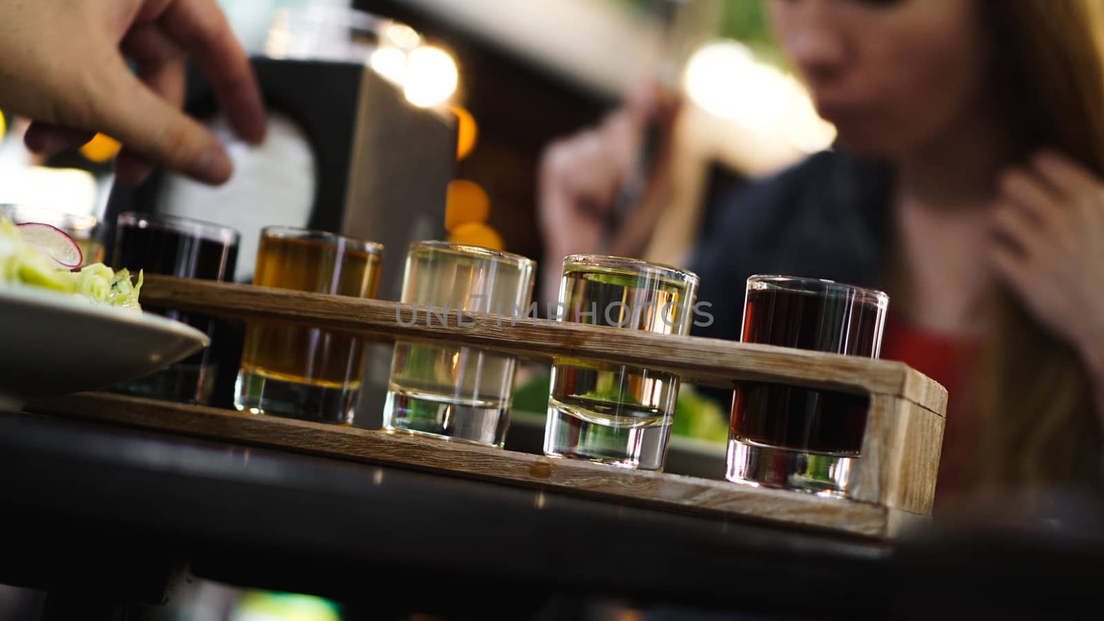 Multicolored transparent cocktails, a set of shots in one row, six servings on a wooden stand, substrate. Drink for the menu restaurant, bar, cafe