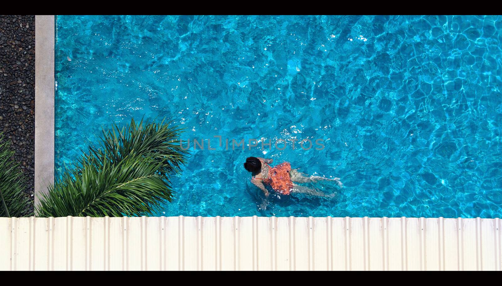 Swimming pool top view angle which blue color clear water and sun light reflect on surface texture and concept images for relaxation or vacation or sport in the tropical summer and for healthy lifestyle