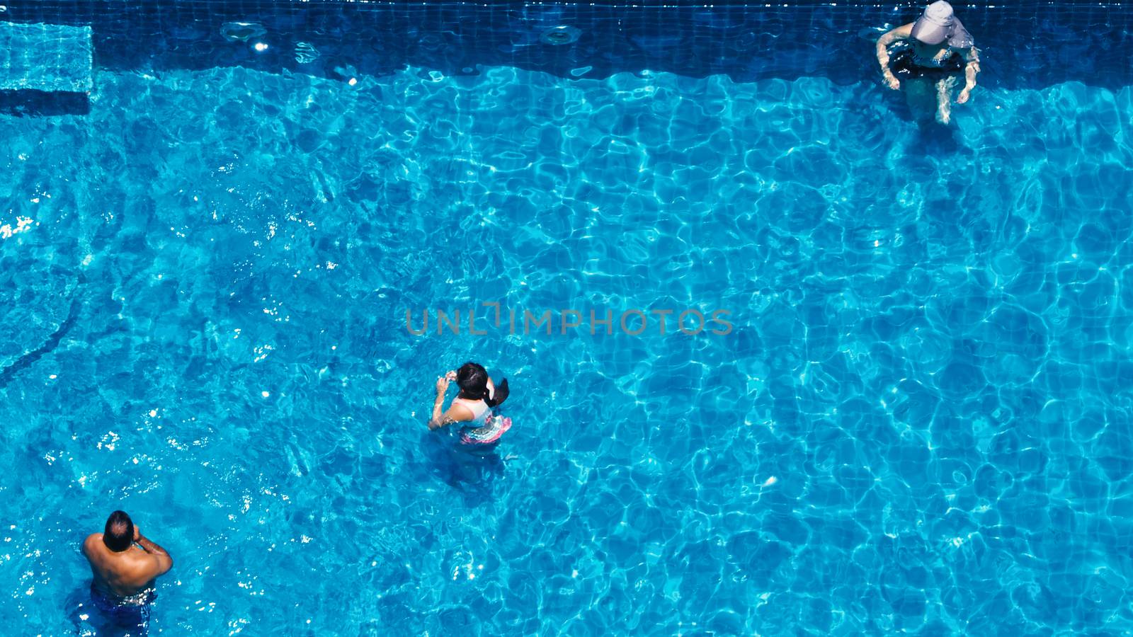 Swimming pool top view angle which blue color clear water and sun light reflect on surface texture and concept images for relaxation or vacation or sport in the tropical summer and for healthy lifestyle