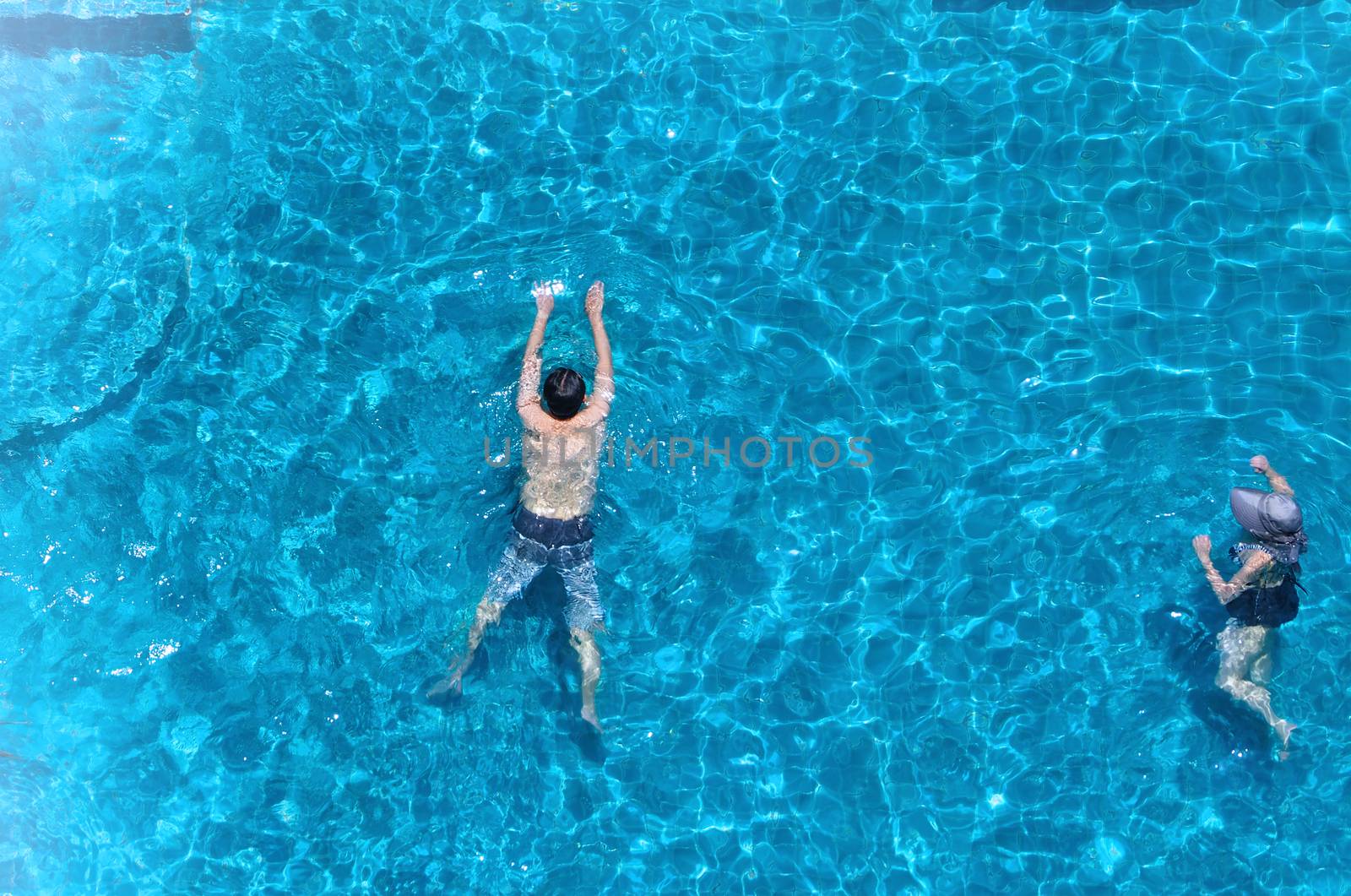 Swimming pool top view angle which blue color clear water and sun light reflect on surface texture and concept images for relaxation or vacation or sport in the tropical summer and for healthy lifestyle