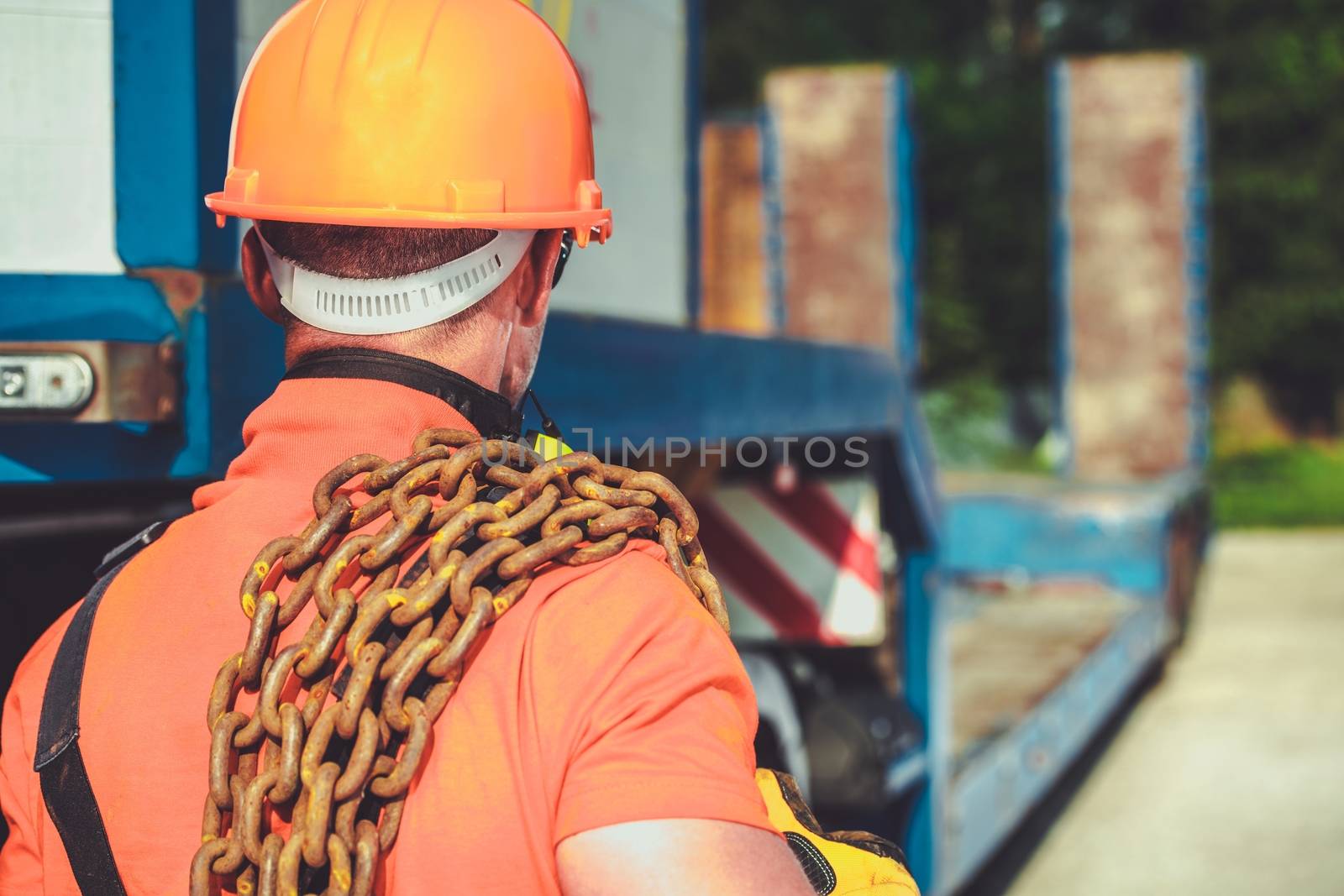 Oversize Load Concept. Caucasian Worker with Large Chain on His Shoulder. Transportation Industry.