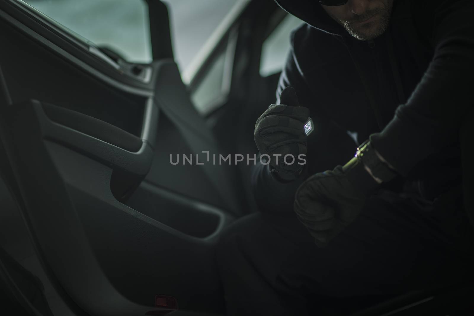 Suspicious Men with Small Flashlight in a Car. Vehicle Theft or Robbery Concept Photo.