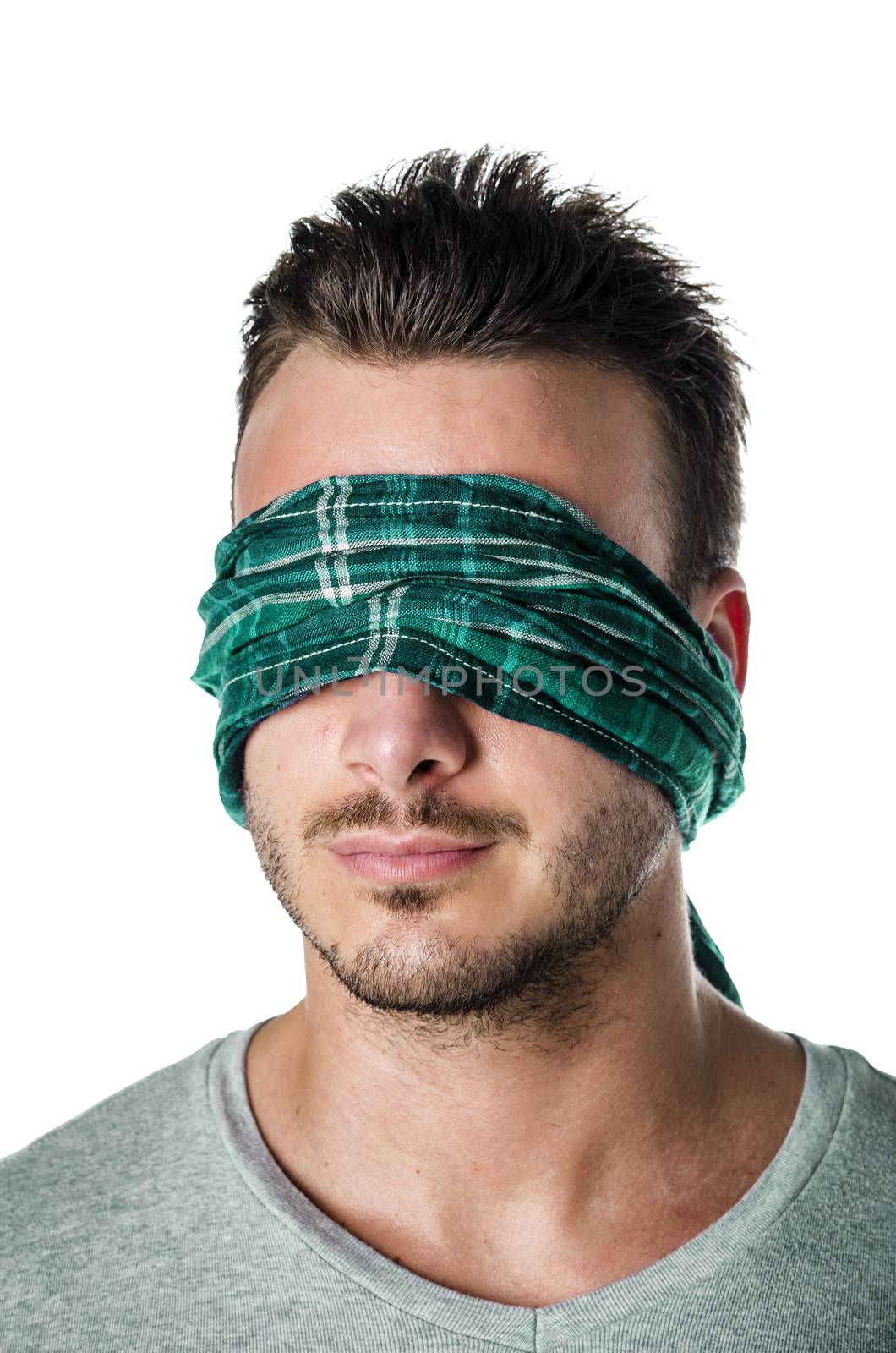Handsome blindfolded young man with eyes covered. Concept of confusion, problem, challenge, losing your way. Isolated on white