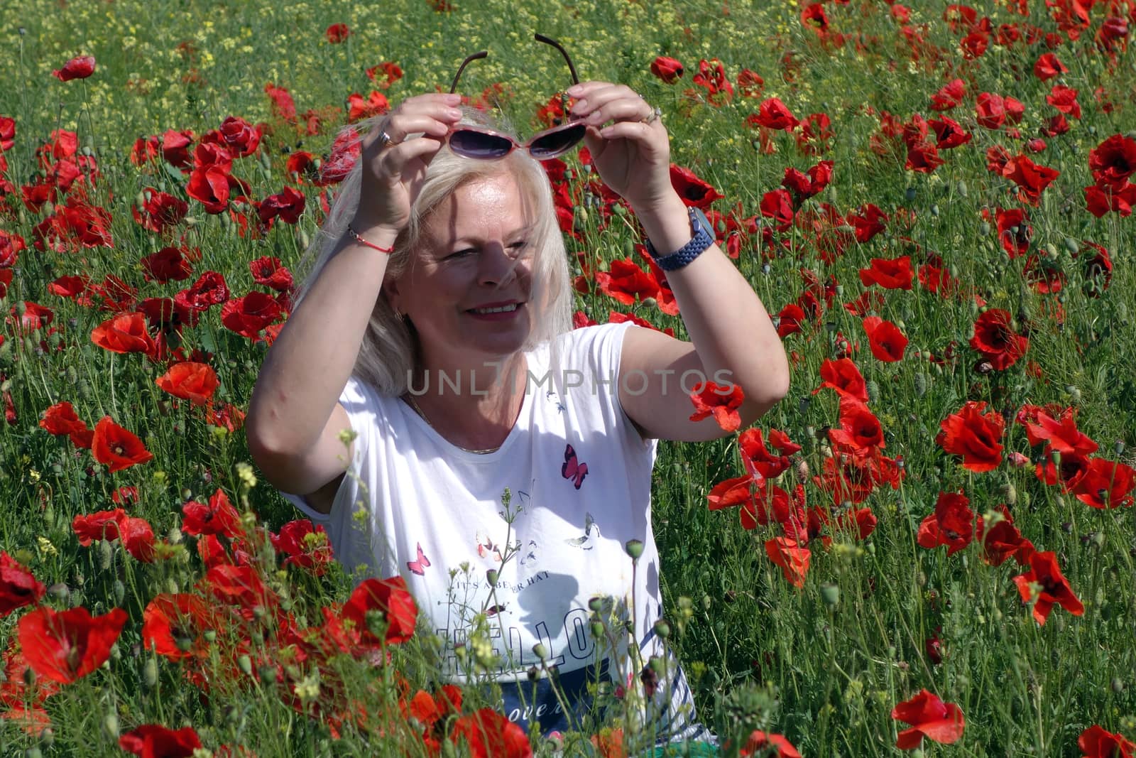 The Romanian Plain at the beginning of the summer.
Carpets poppy cover the wheat fields
A woman stopped to enjoy the image of the poppy in the fields of green wheat
