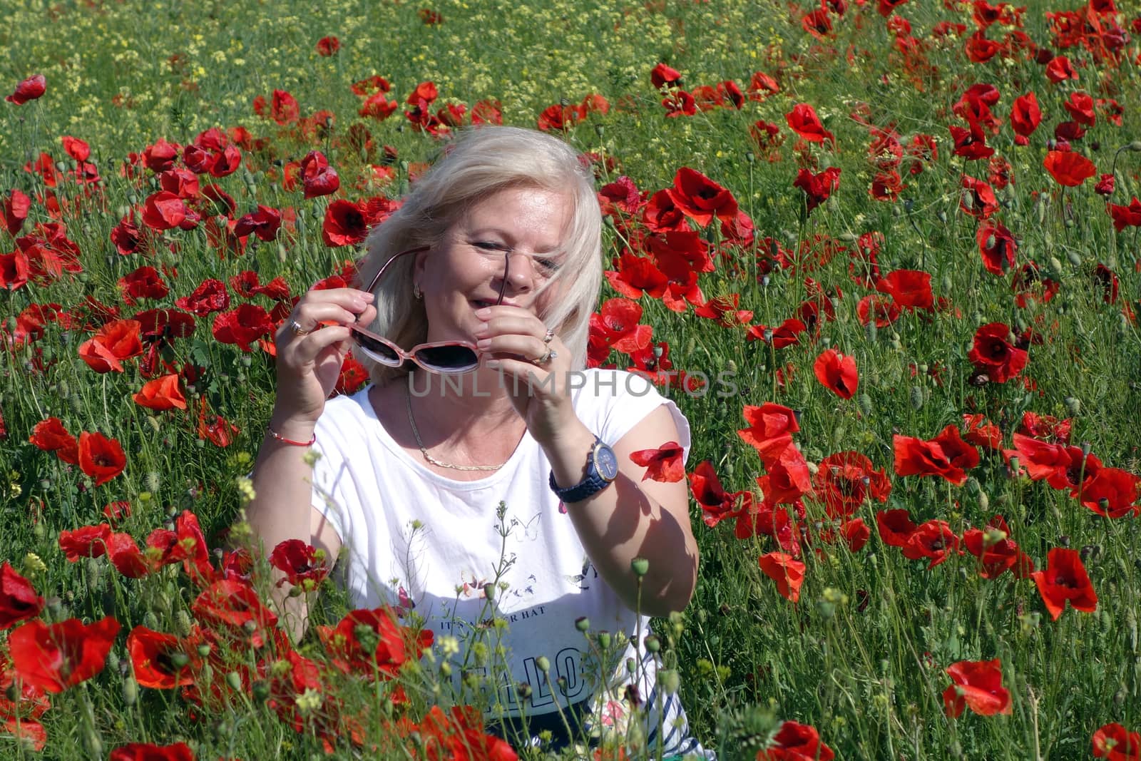 The Romanian Plain at the beginning of the summer.
Carpets poppy cover the wheat fields
A woman stopped to enjoy the image of the poppy in the fields of green wheat