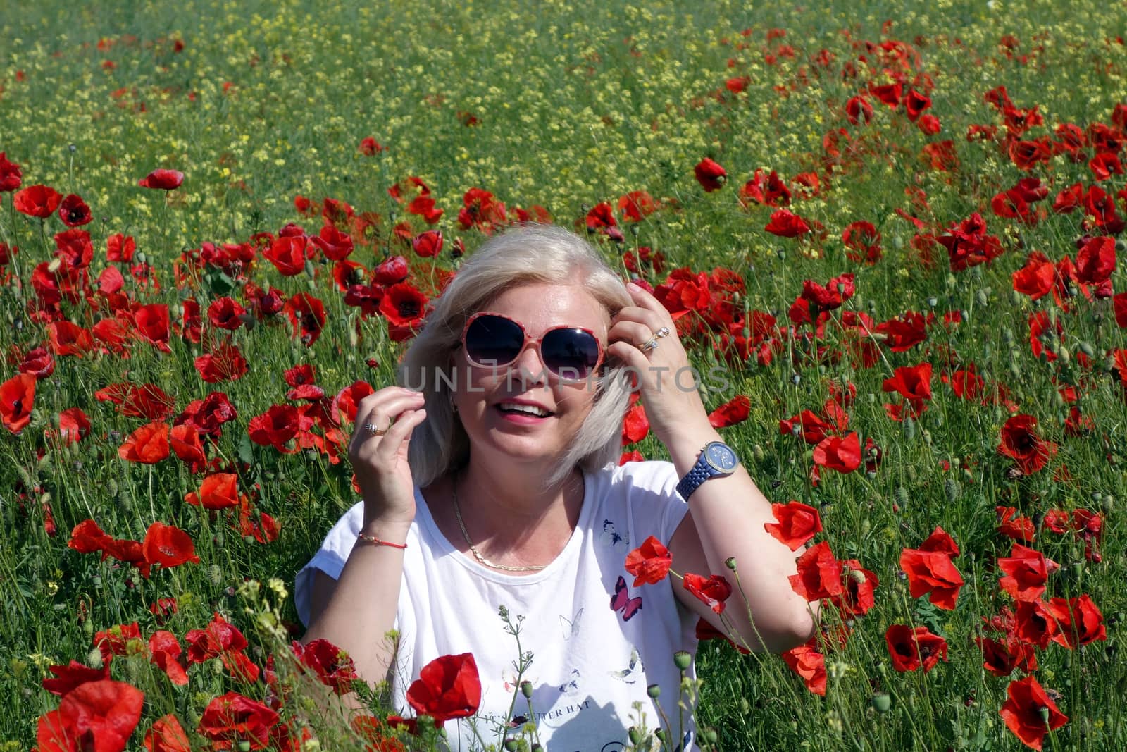 The Romanian Plain at the beginning of the summer.
Carpets poppy cover the wheat fields
A woman stopped to enjoy the image of the poppy in the fields of green wheat