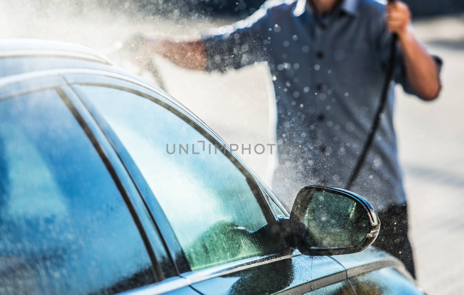 Caucasian Men Cleaning Vehicle in the Car Wash. Closeup Photo. Automotive Theme.