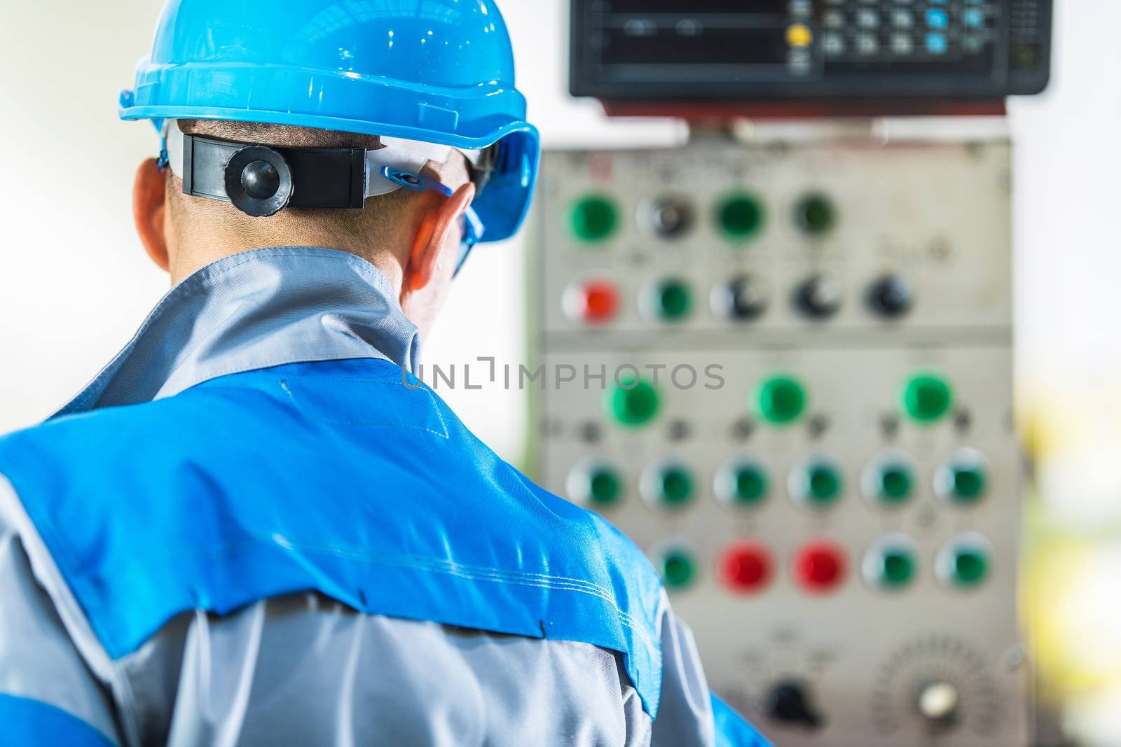 Machinery Operator Console. Caucasian Production Line Technician In Front of Machine Control Panel