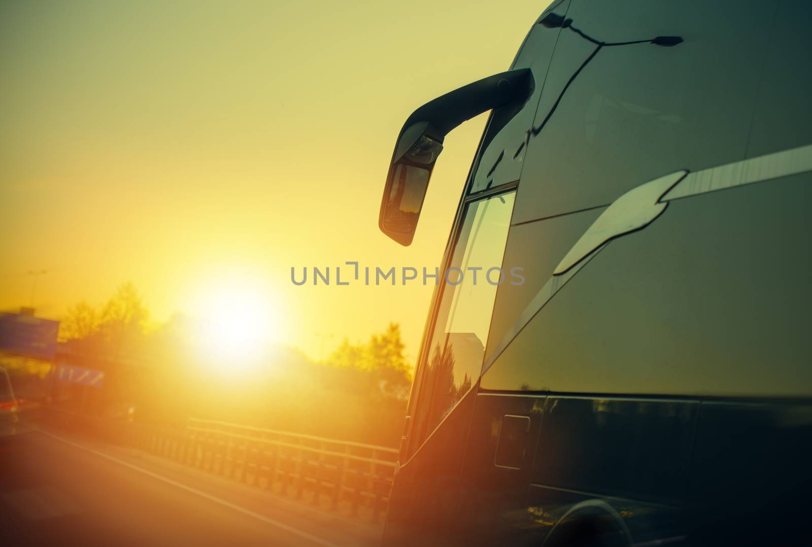 Motor Coach Bus on the Route During Scenic Sunset. Bus Transportation.