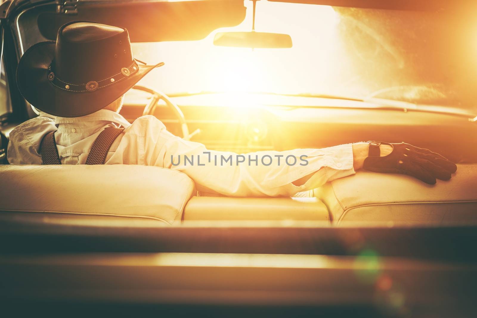 Going to the Sun Road. Western Wear Men in Cowboy Hat Driving Classic Convertible Car. American Dream Retro Style Concept.