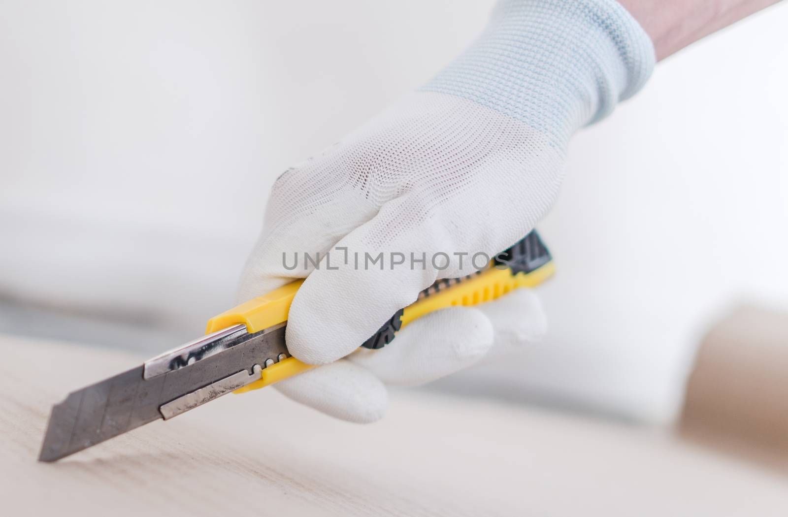 Wallpaper Knife Cutter in Hand. Closeup Photo. Paper Cutting.