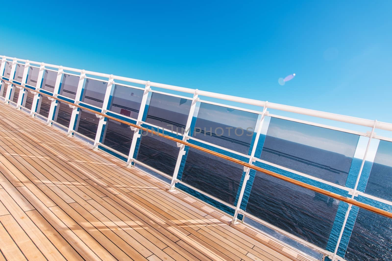 Cruise Ship Vacation Theme. Wooden Deck of the Cruise Vessel with Glassy Barriers and the Ocean Vista. Caribbean Vacation Time.