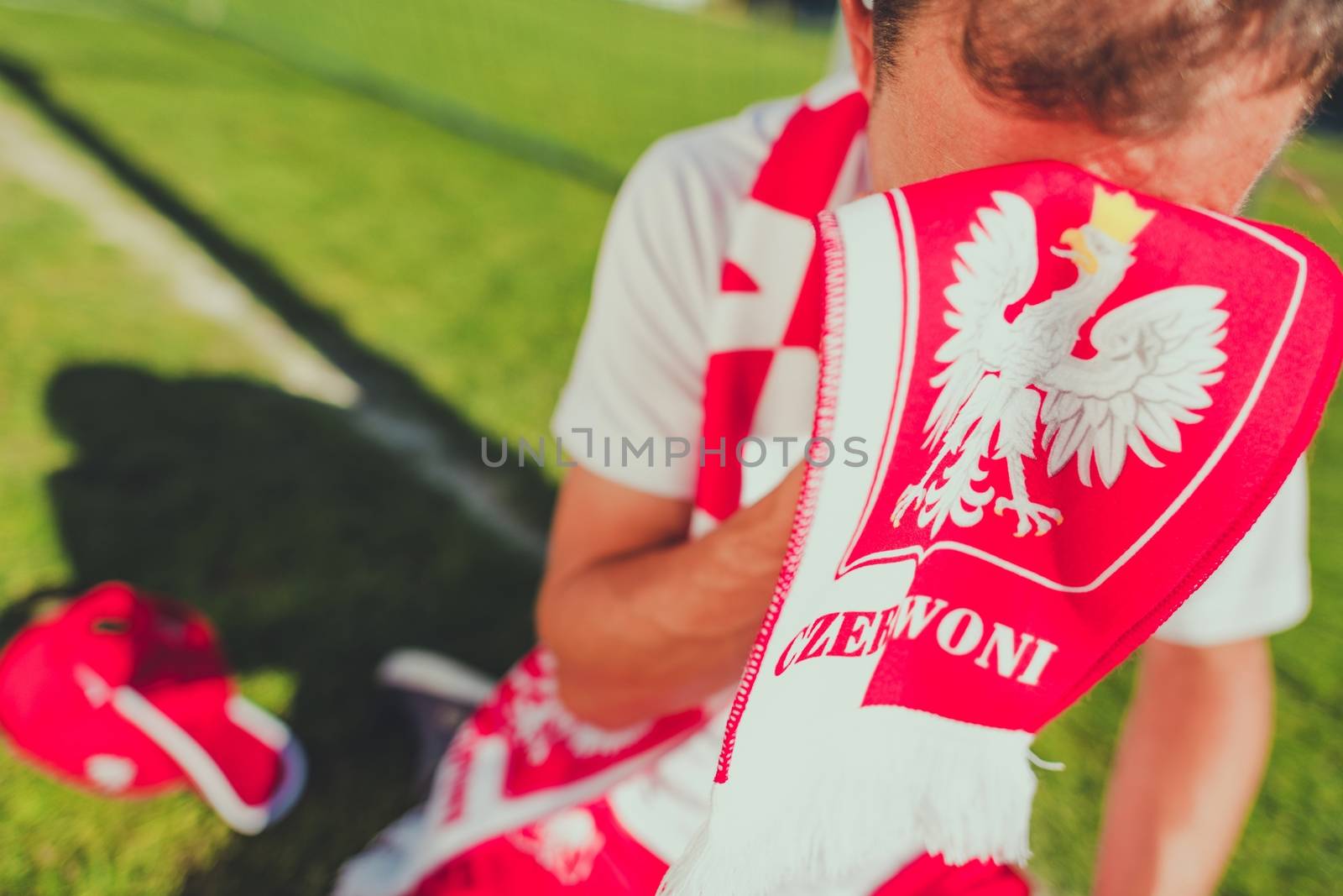 Crying Polish Soccer Fan. Lost Match Theme. Caucasian Football Fan Covering His Face by National Team Red and White Scarf with Polish Emblems.