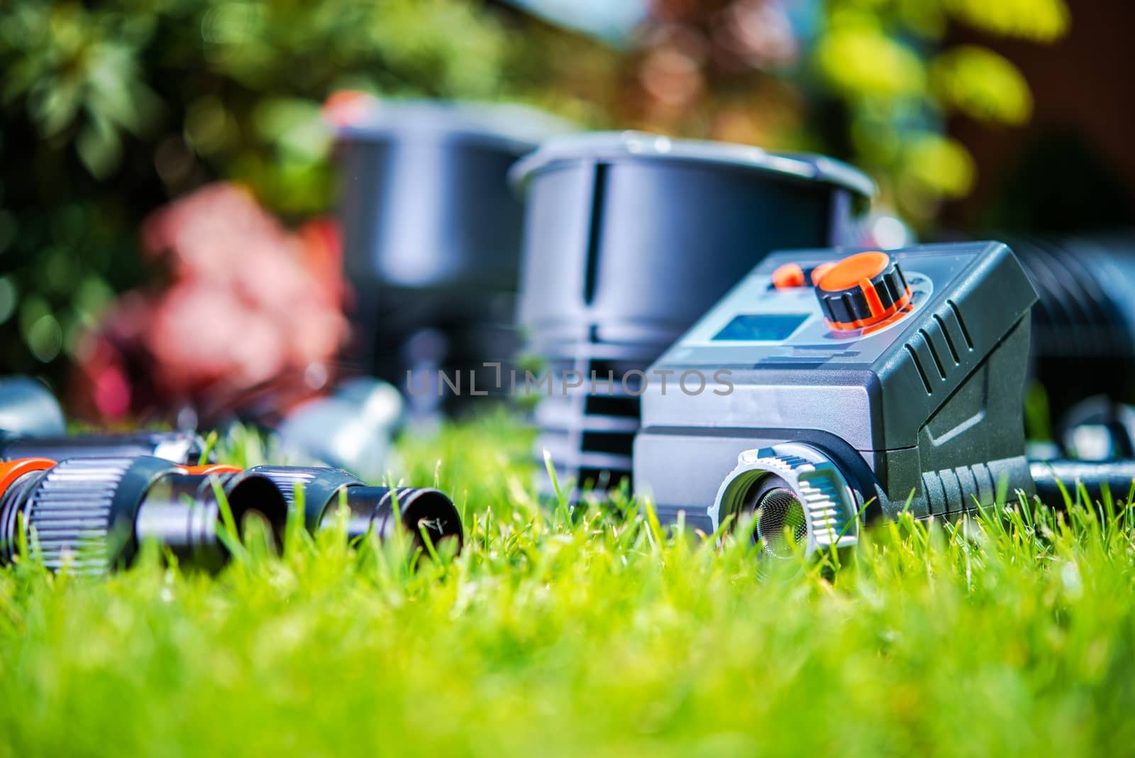 Garden Watering System Elements in the Grass. Closeup Photo. Building Automatic Backyard Water Sprayers.