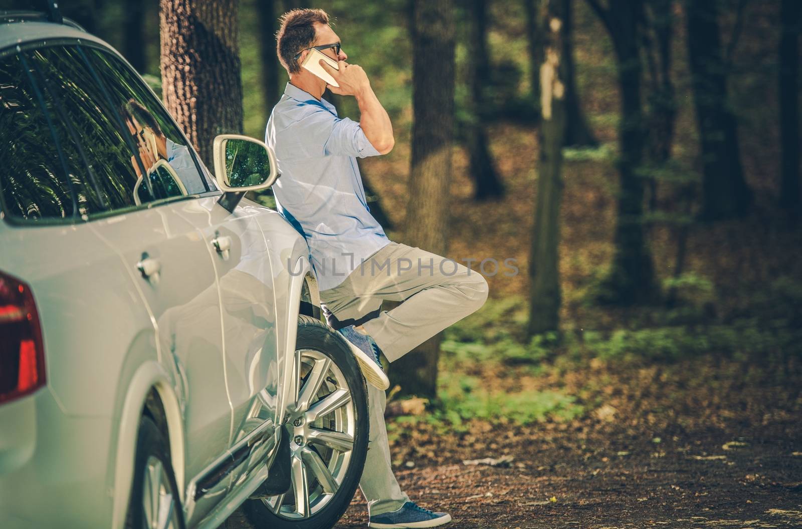 Caucasian Men in His 30s Making Cellphone Conversation Inside the Forest. Office Worker Taking Short Break From His Work.