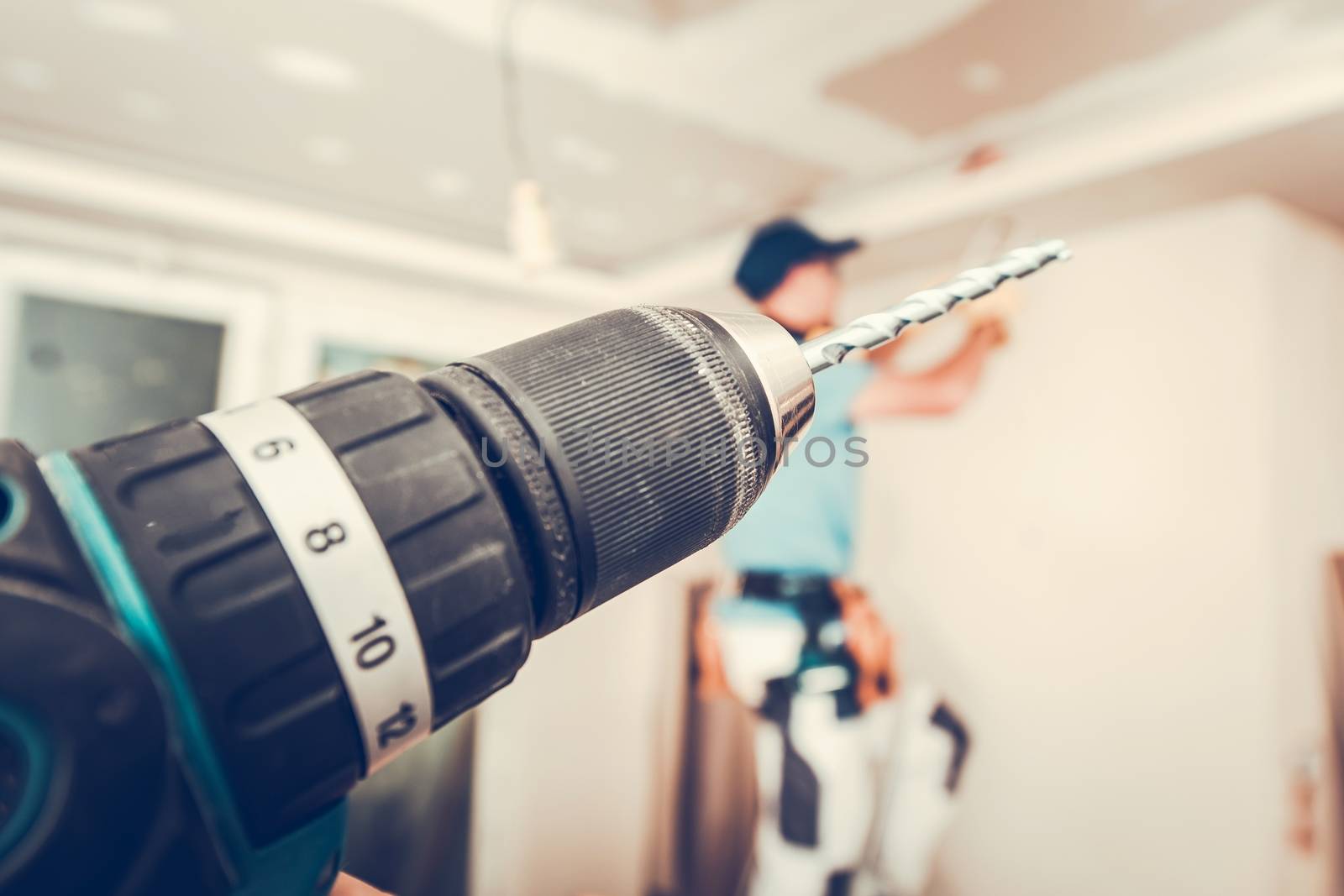 Apartment Remodeling with Power Tools, Cordless Drill Driver and Working Contractor in the Background.