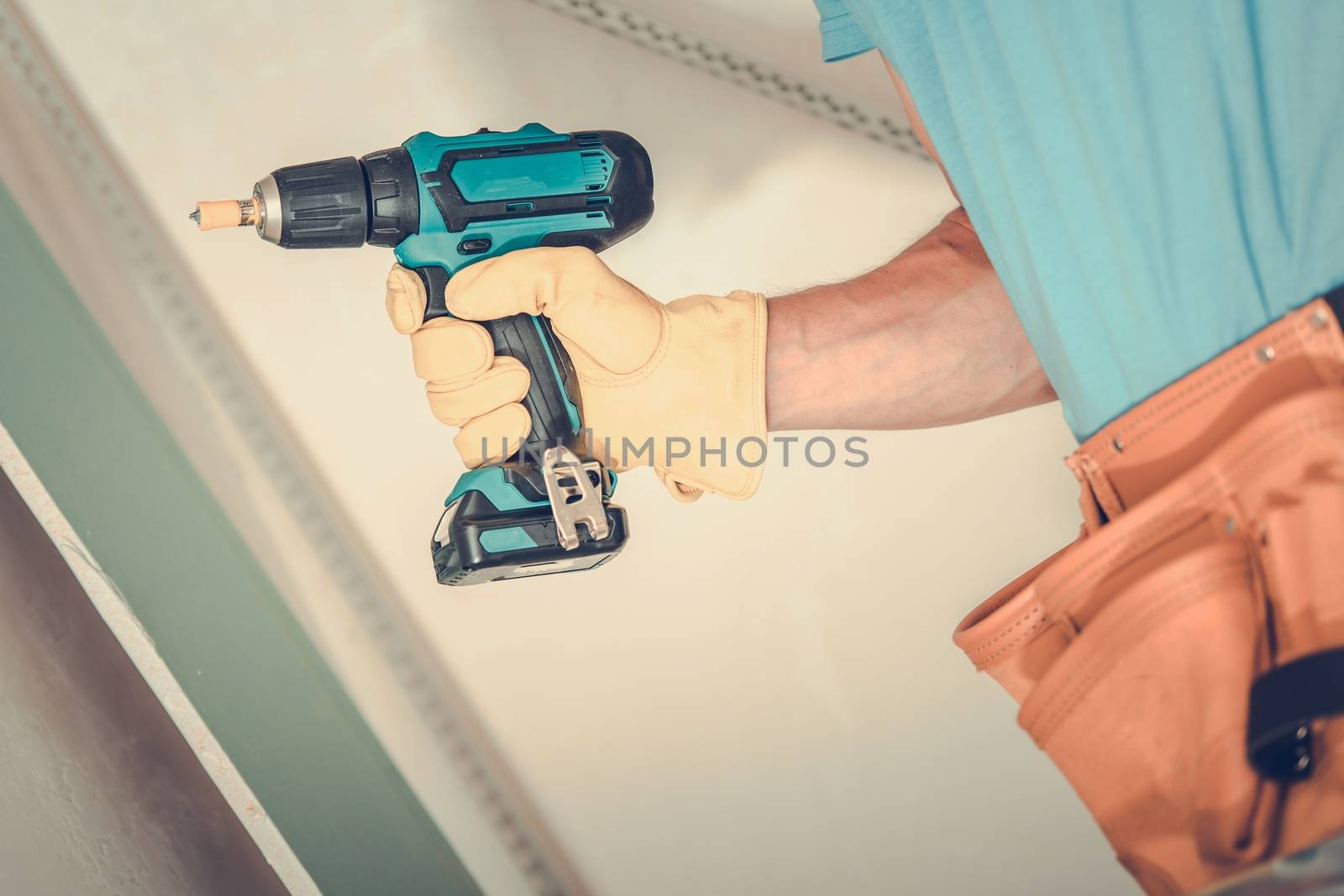 Drywall Building. Contractor with Drill Driver Closeup Photo. Construction Theme.