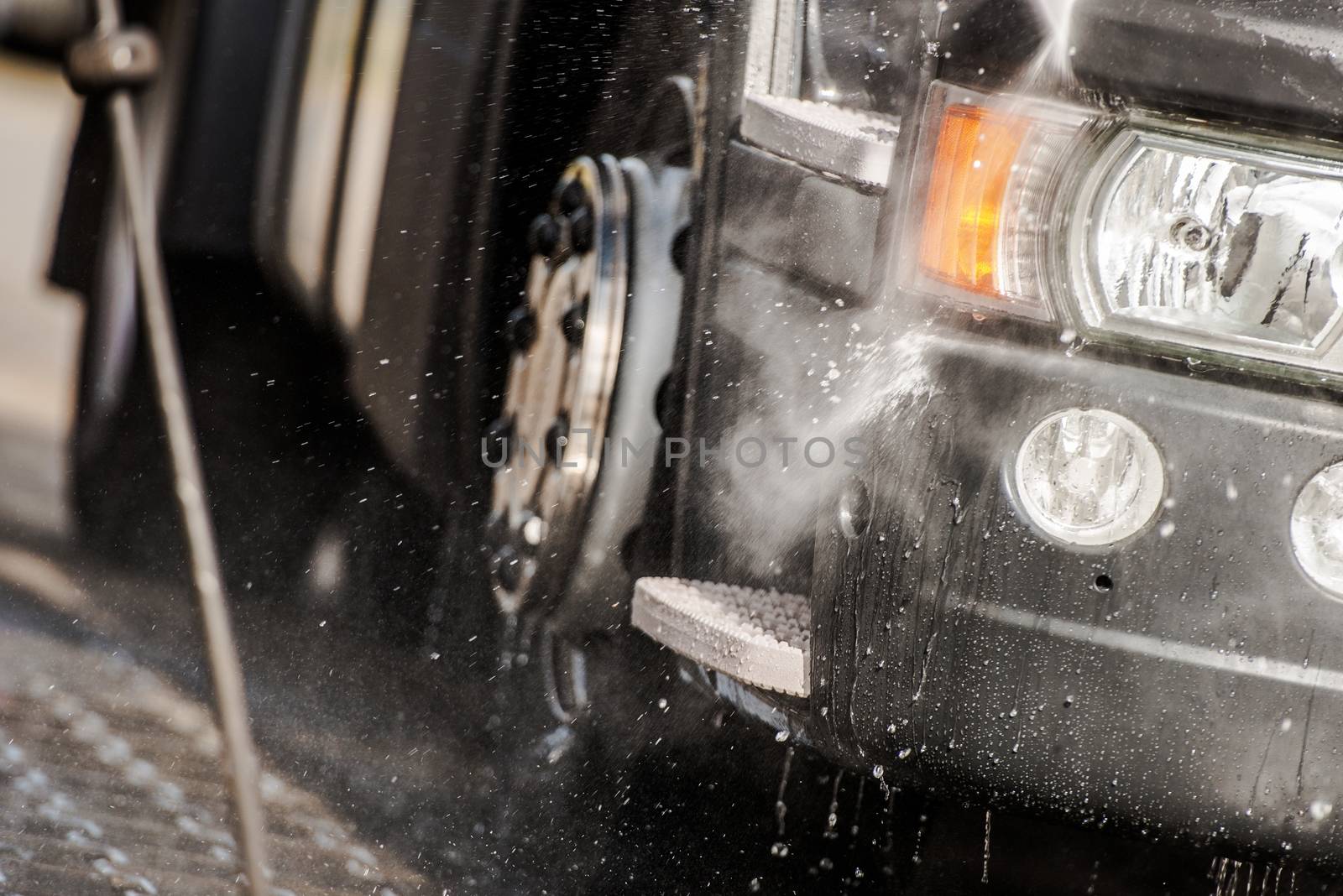 Semi Tractor in the Truck Wash Closeup Photo. Taking Care of the Vehicle.