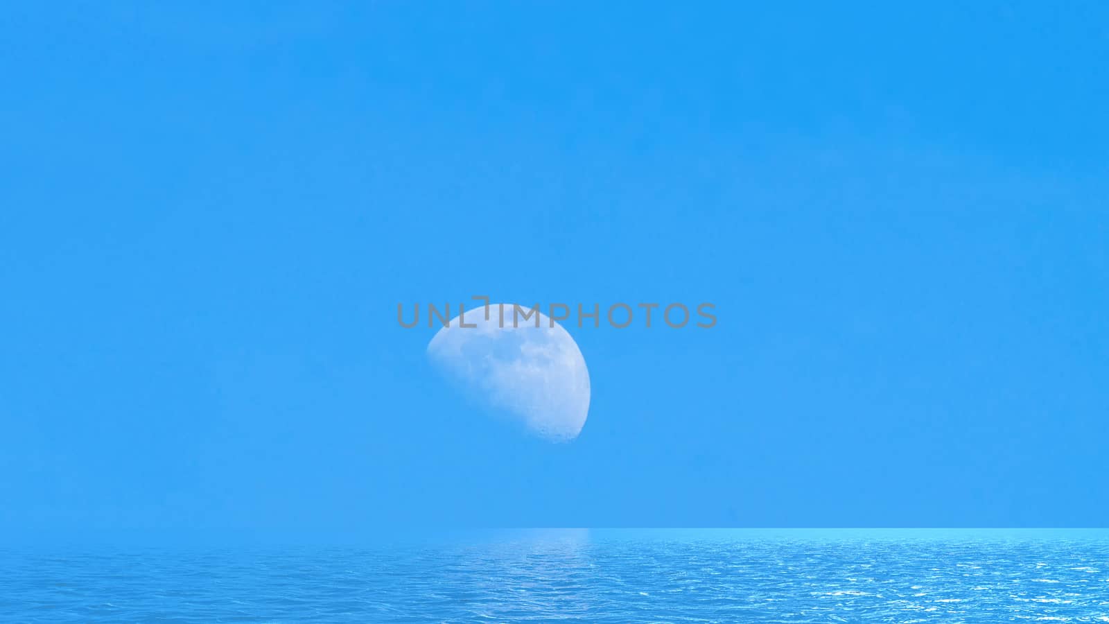 Moon over the blue wide sea with reflections