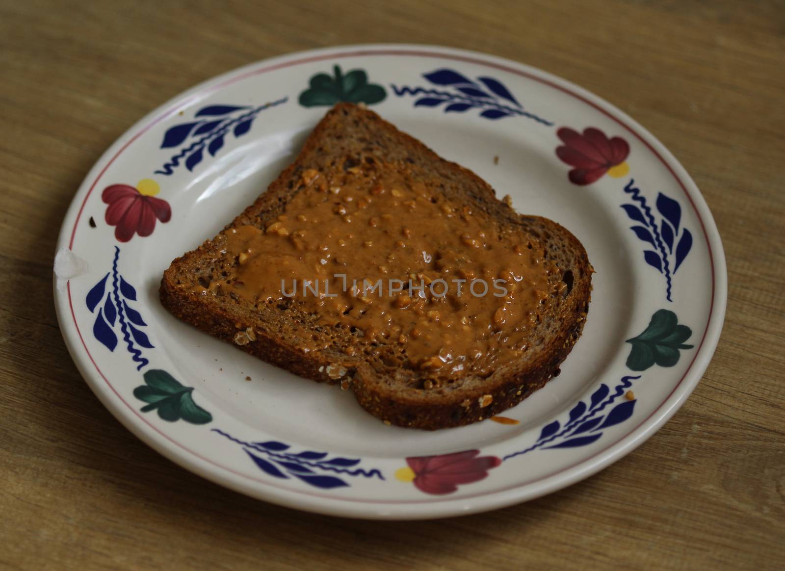 close up of Bread with peanut butter on white plate on wooden background