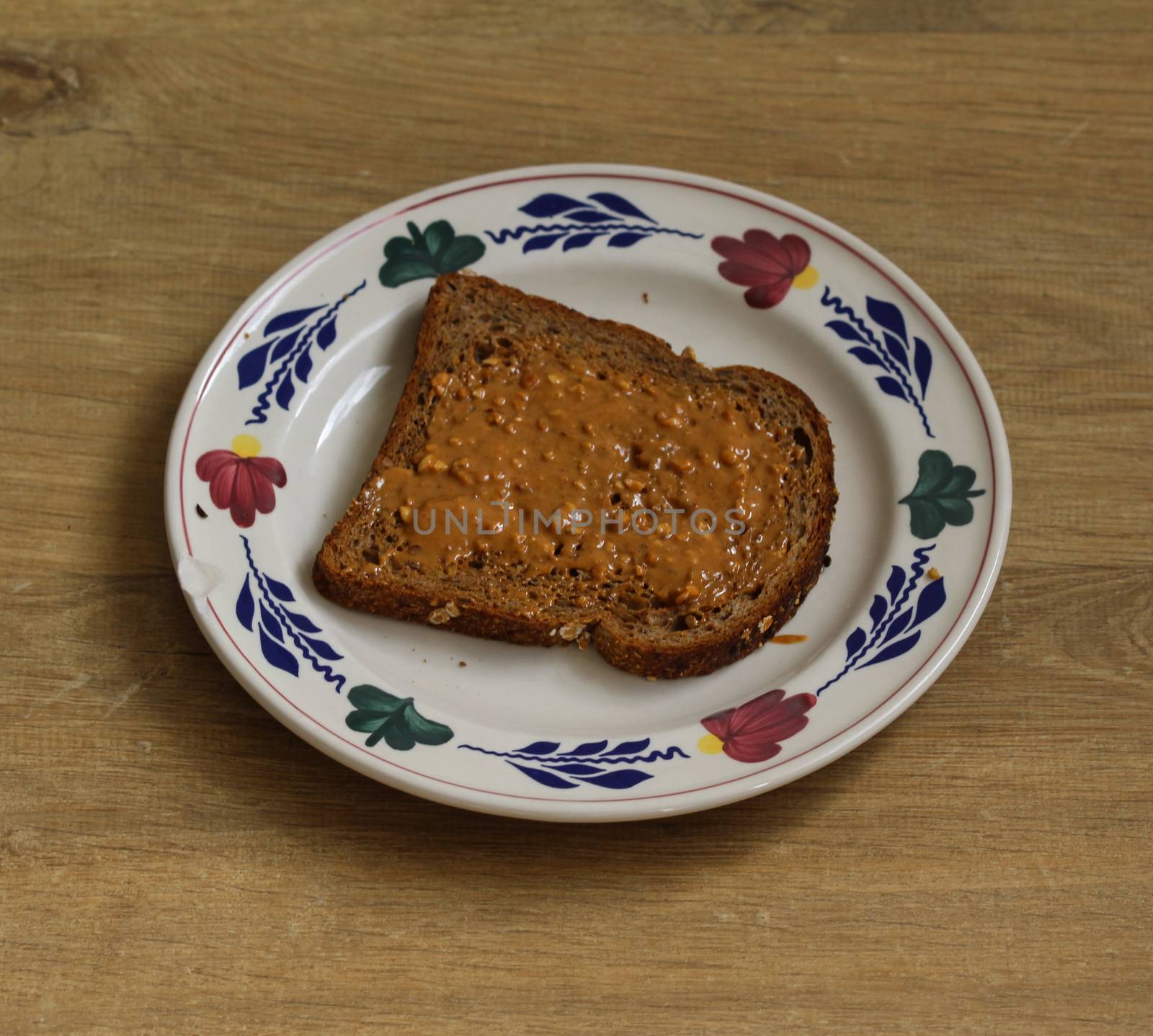 close up of Bread with peanut butter on white plate on wooden background