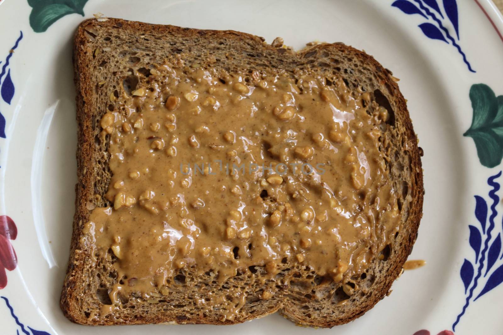 close up of Bread with peanut butter on white plate on wooden background