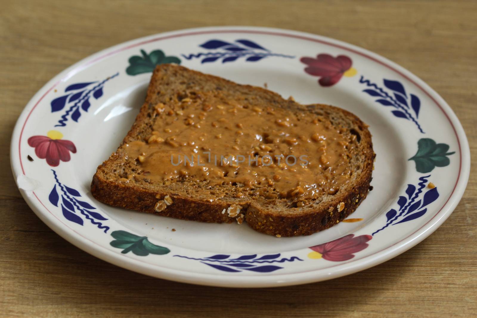 close up of Bread with peanut butter on white plate on wooden background