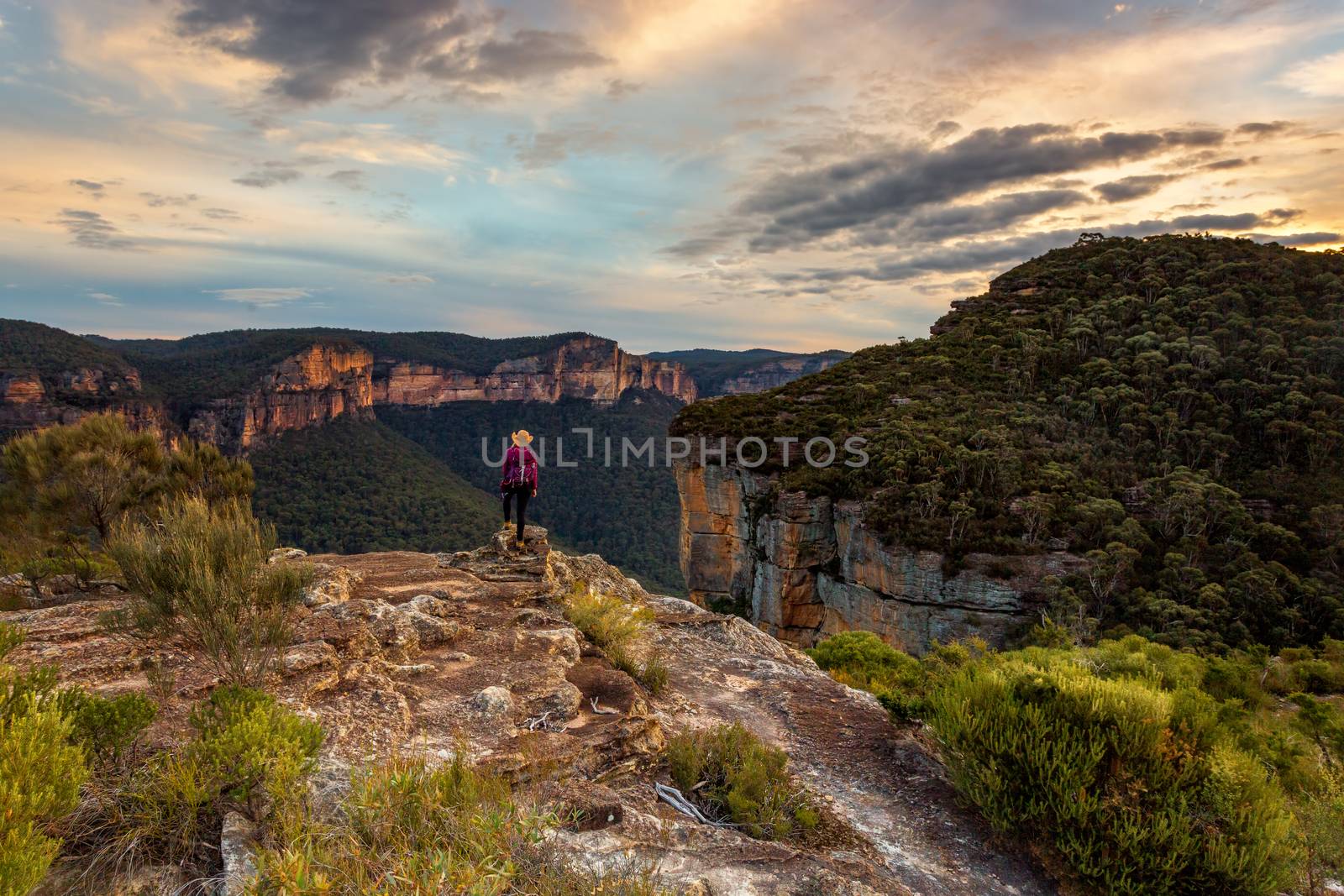 Female stands in awe taking in the magnificent cliff top views of mountain escarpments and the Grose Valley, Blue Mountains, Australia
