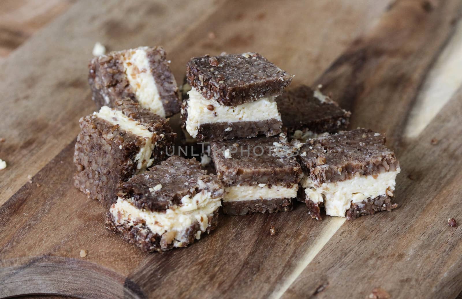 close up of rye bread with aged cheese on wooden background