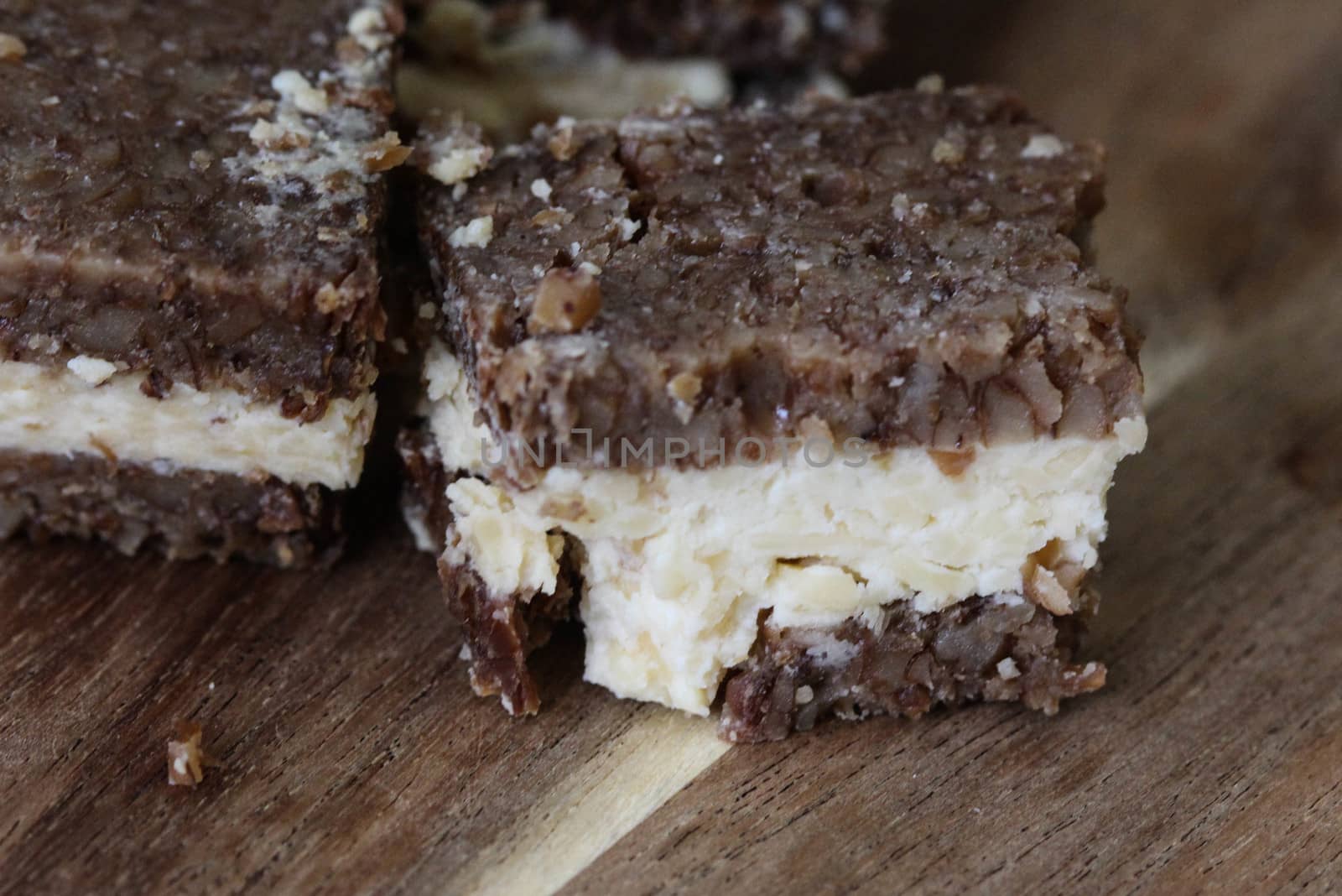 close up of rye bread with aged cheese on wooden background