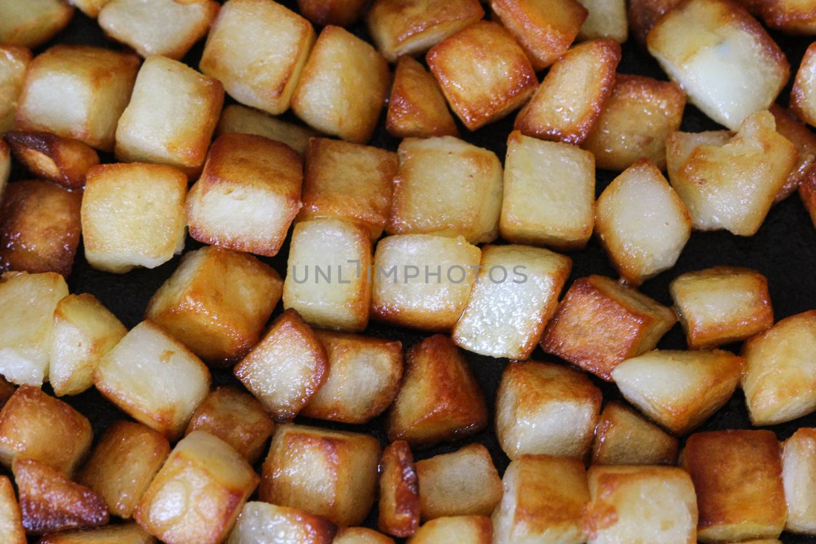 close up of baked potato cubes in pan in kitchen