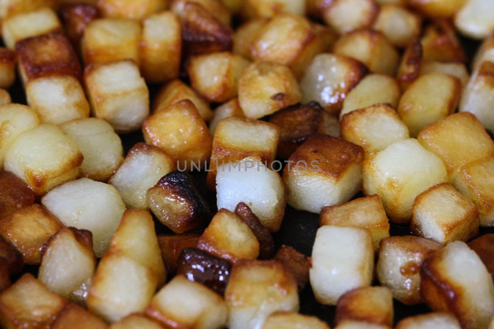 close up of baked potato cubes in pan in kitchen