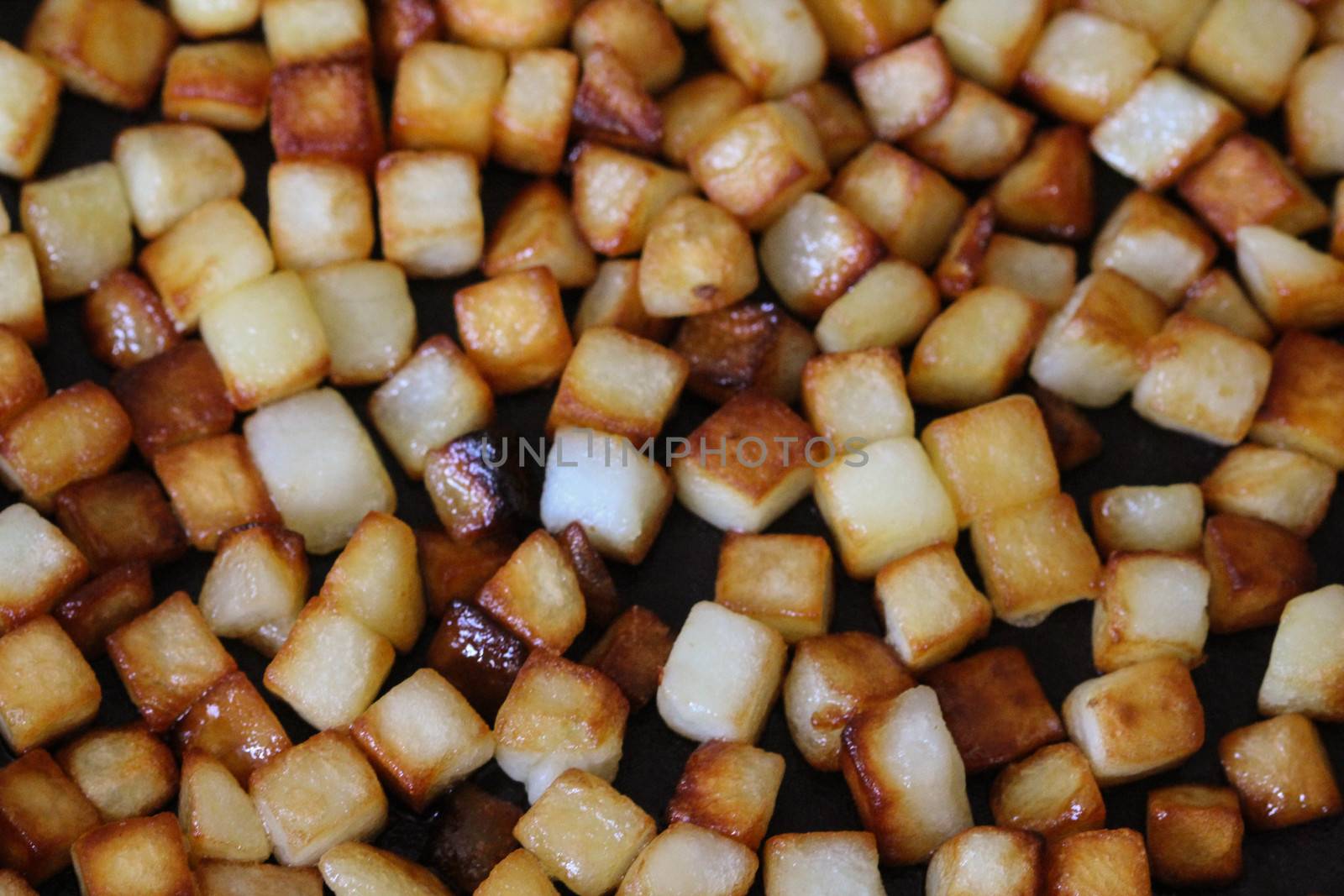 close up of baked potato cubes in pan in kitchen