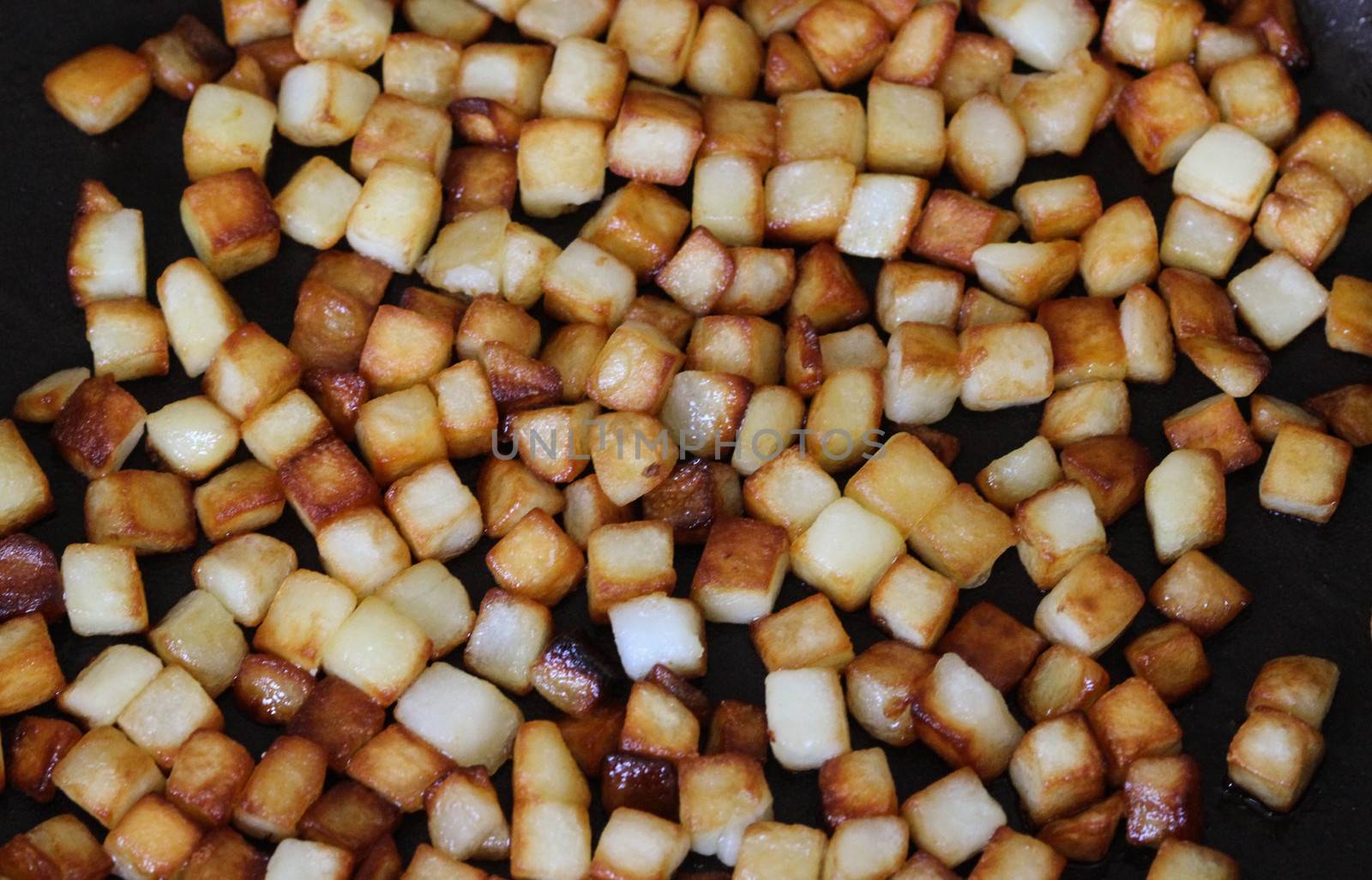 close up of baked potato cubes in pan in kitchen