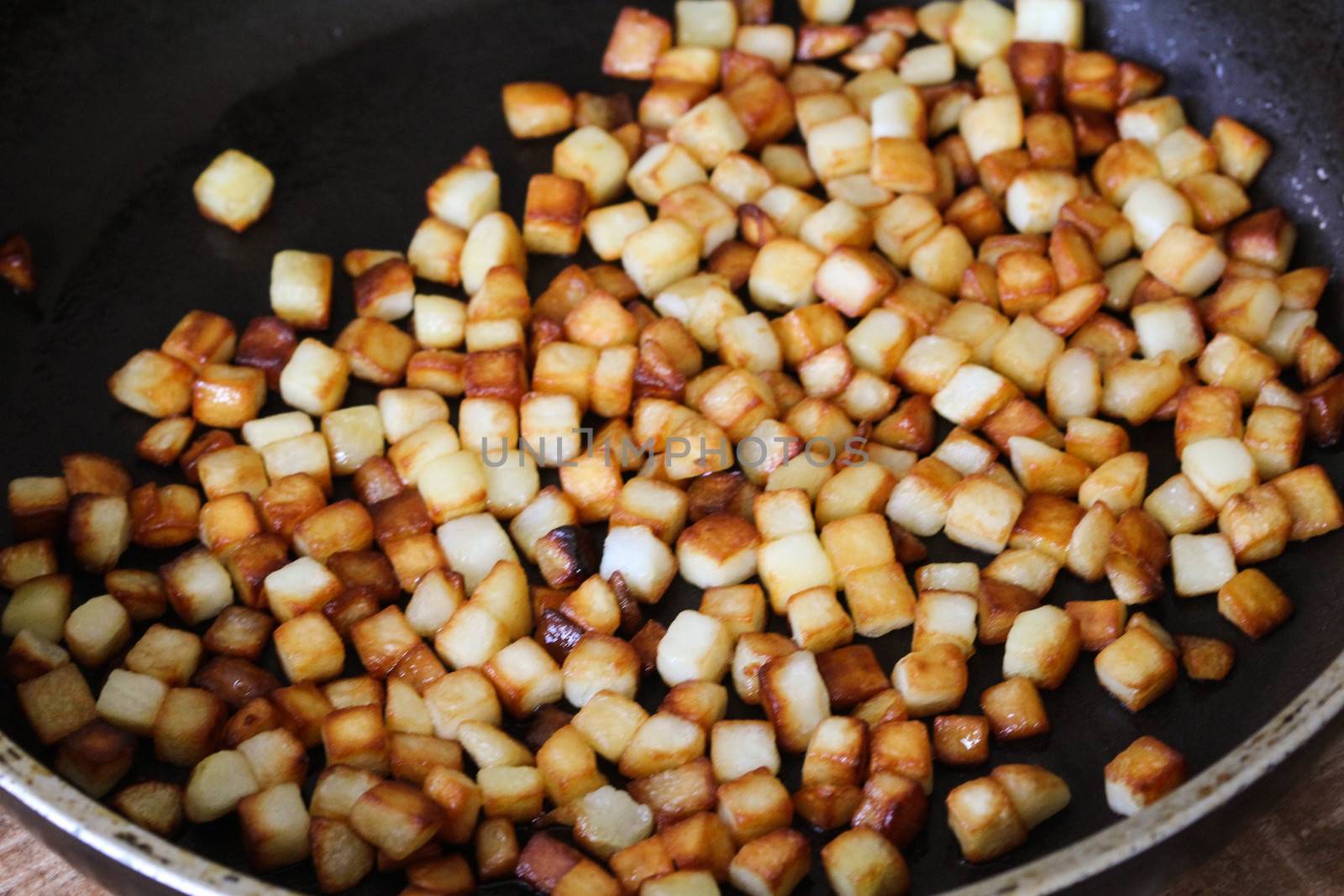 close up of baked potato cubes in pan in kitchen