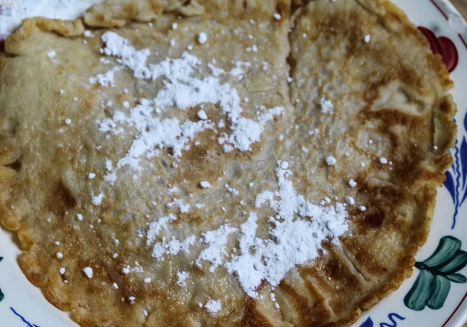 close up of pancake with powdered sugar