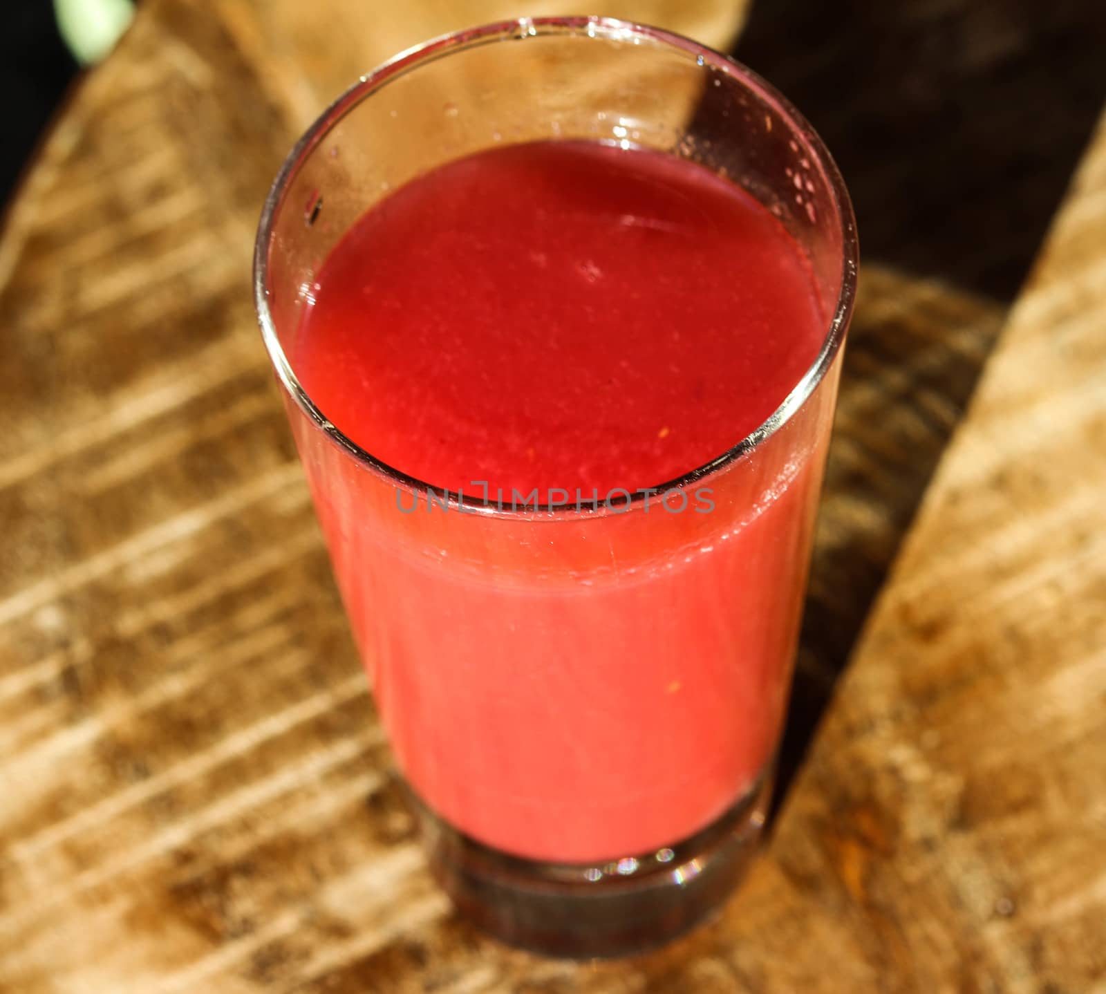close up of a glass with strawberry, raspberry, and apple smoothie
