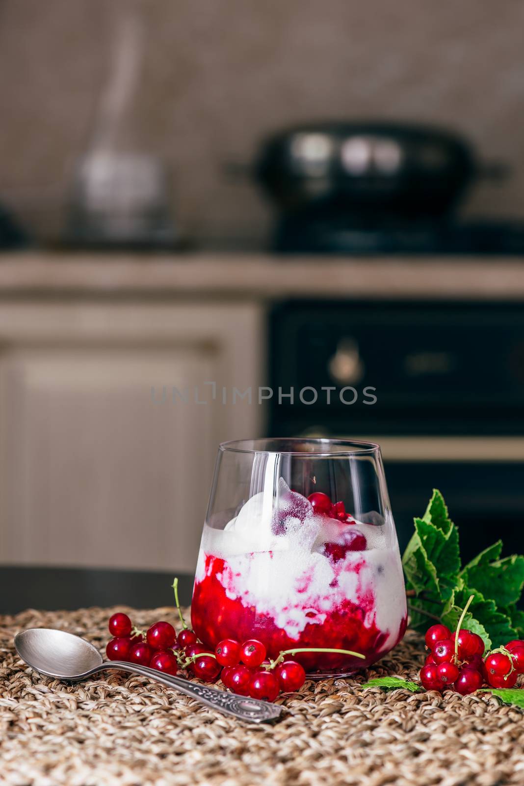Ice Cream Dessert with Red Currant Jam and Fresh Berries. Kitchen on Background.