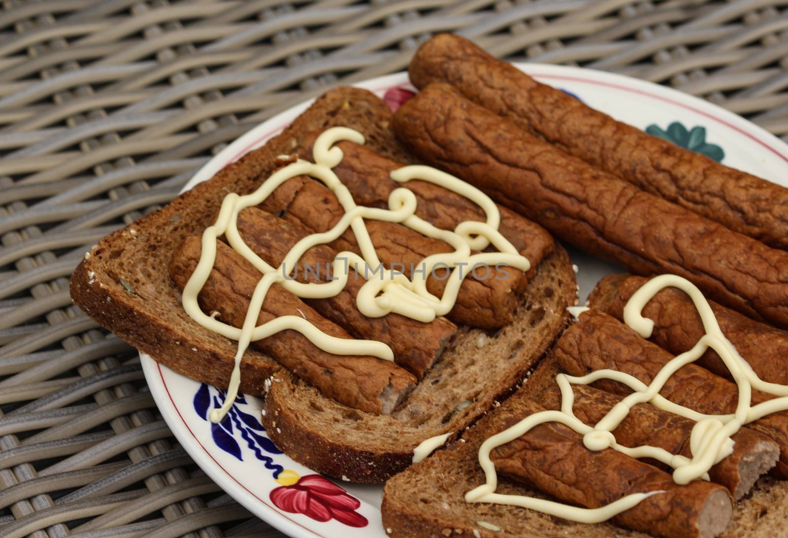 close up of frikandel on bread with mayonnaise, a traditional Dutch snack, a sort of minced meat hot dog