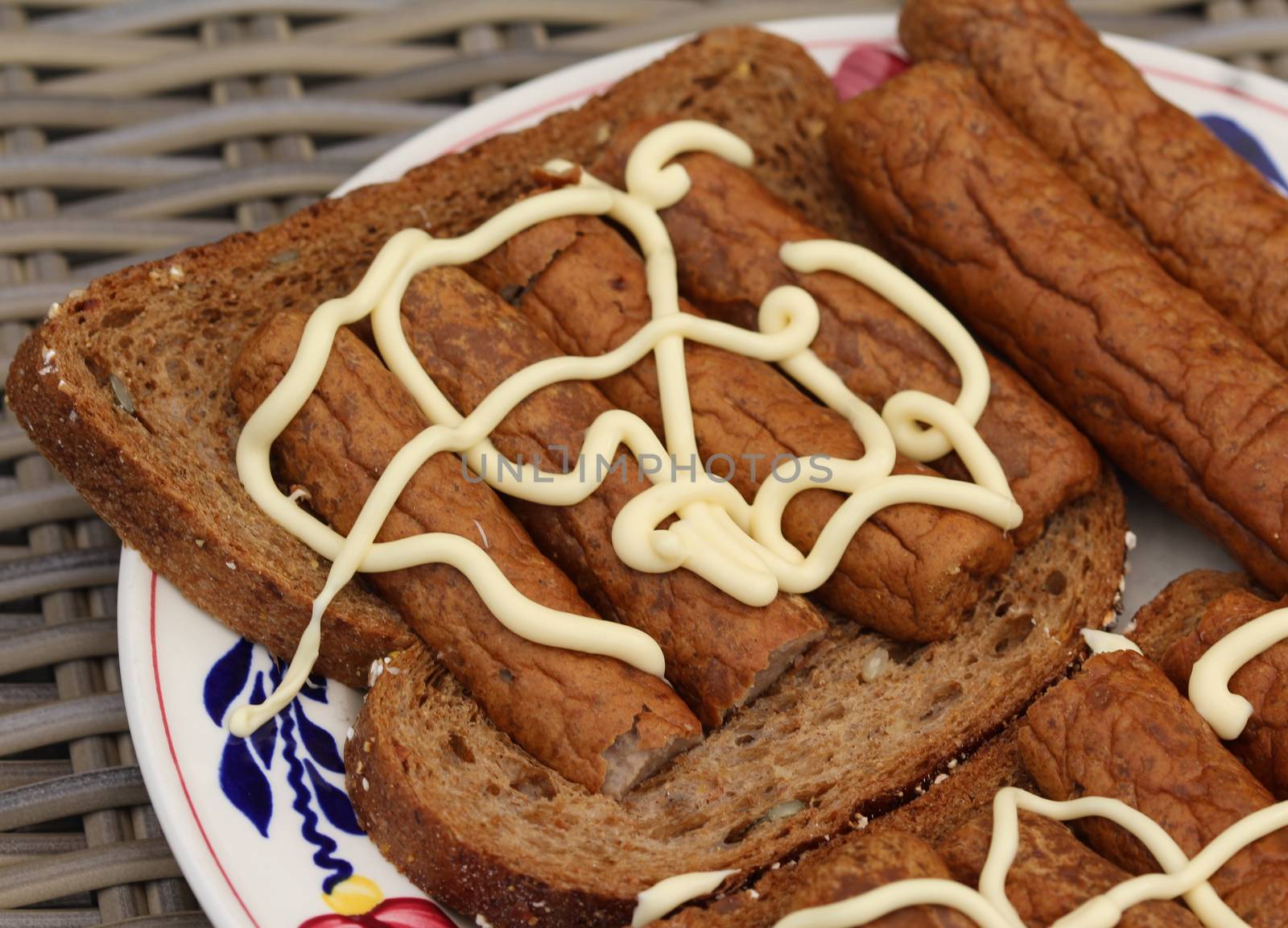 close up of frikandel on bread with mayonnaise, a traditional Dutch snack, a sort of minced meat hot dog