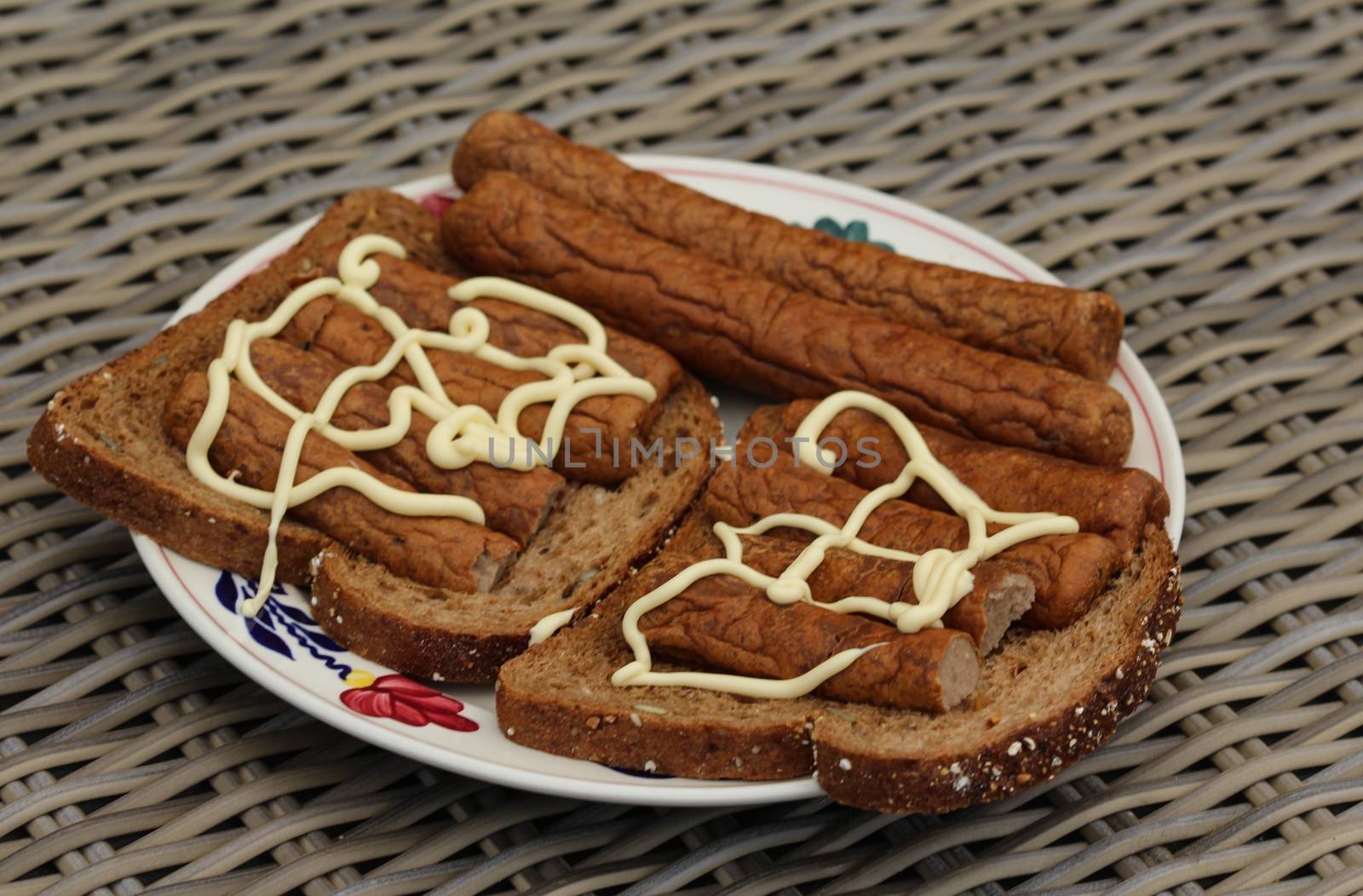 close up of frikandel on bread with mayonnaise, a traditional Dutch snack, a sort of minced meat hot dog