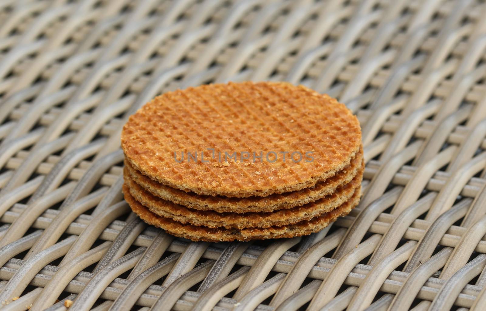 close up of stack of traditional dutch stroopwafels cookie, a caramel syrup waffle, on wooden background